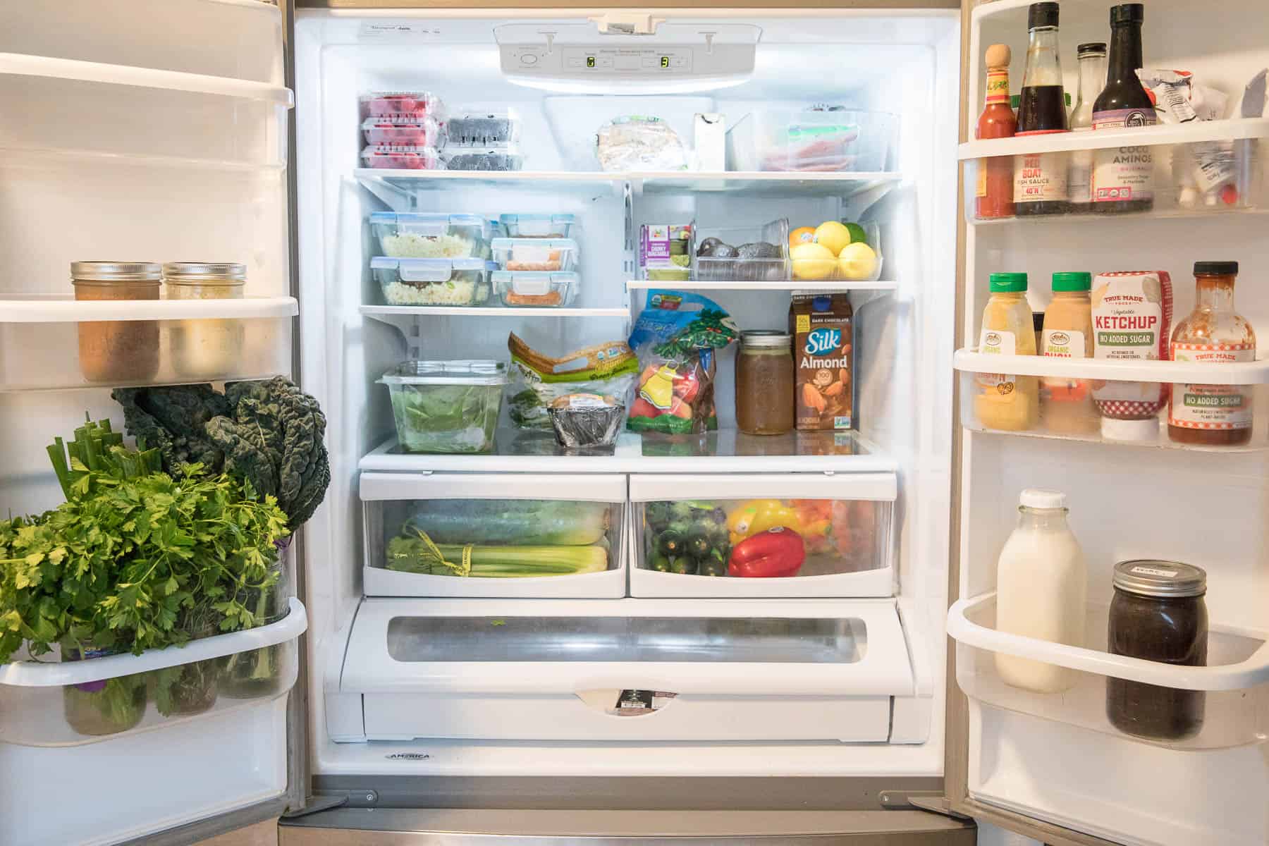 organized keto refrigerator with produce, meal prep, condiments