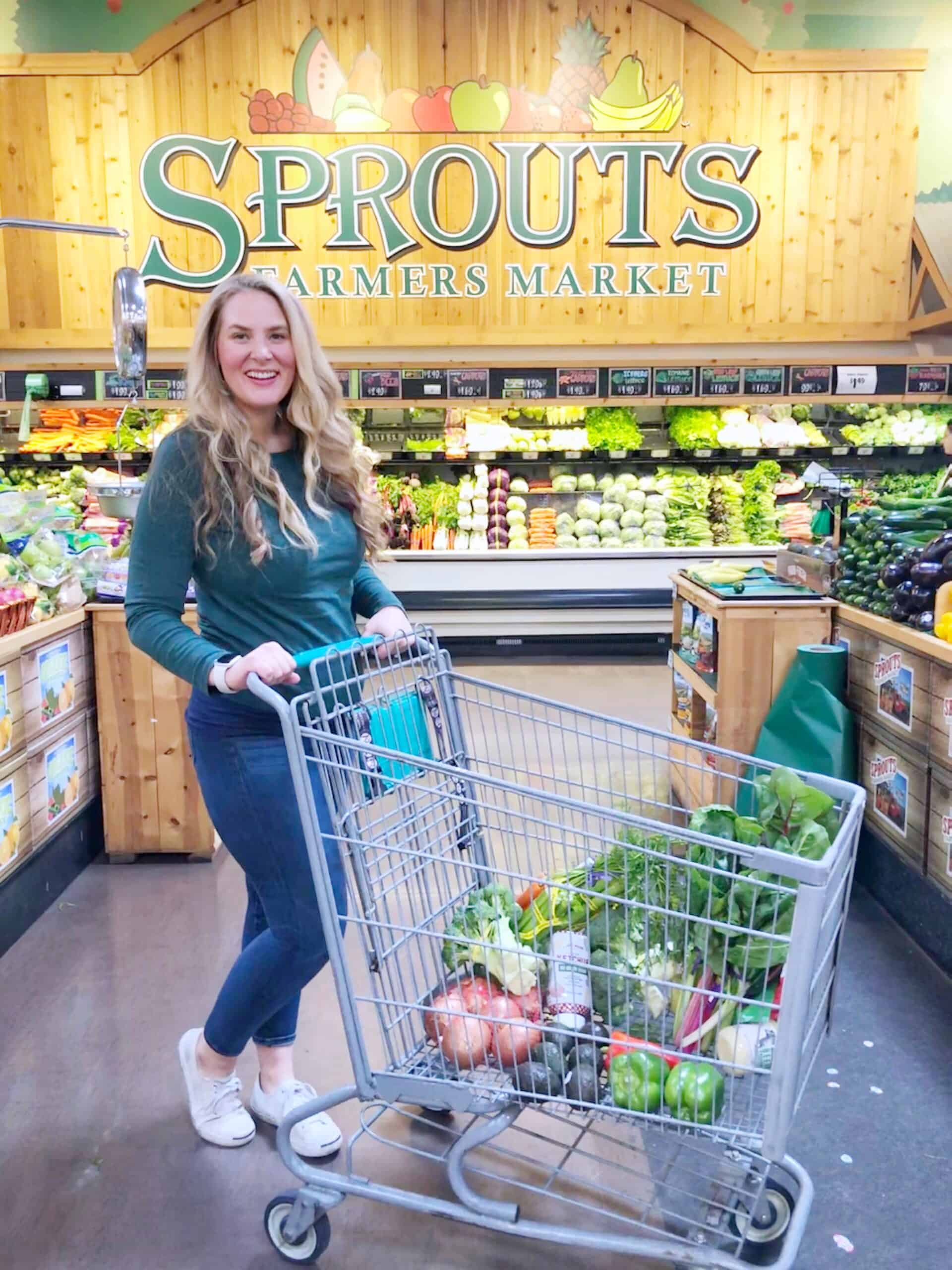 girl grocery shopping at Sprouts pushing a grocery cart in the produce department