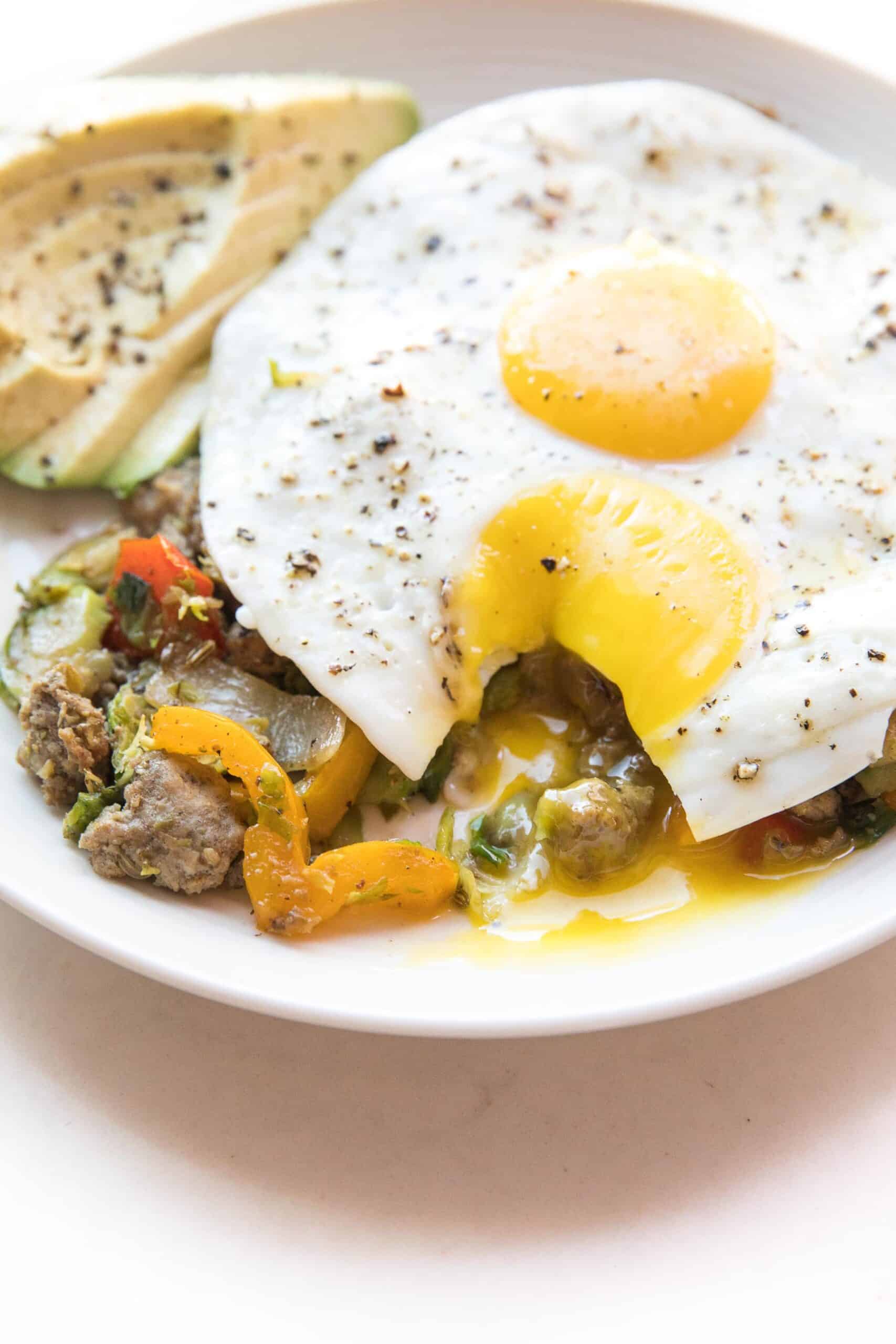 sunny side up egg yolk dripping on sausage + brussels hash