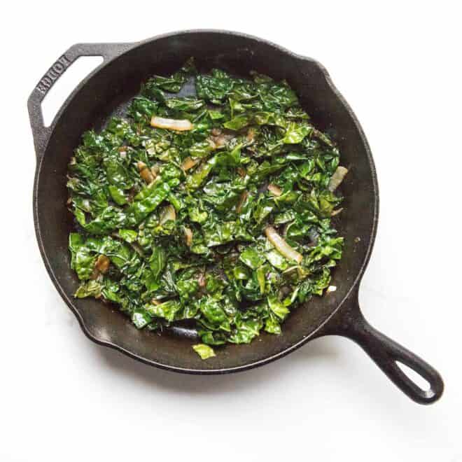 sauteed kale in a cast iron skillet