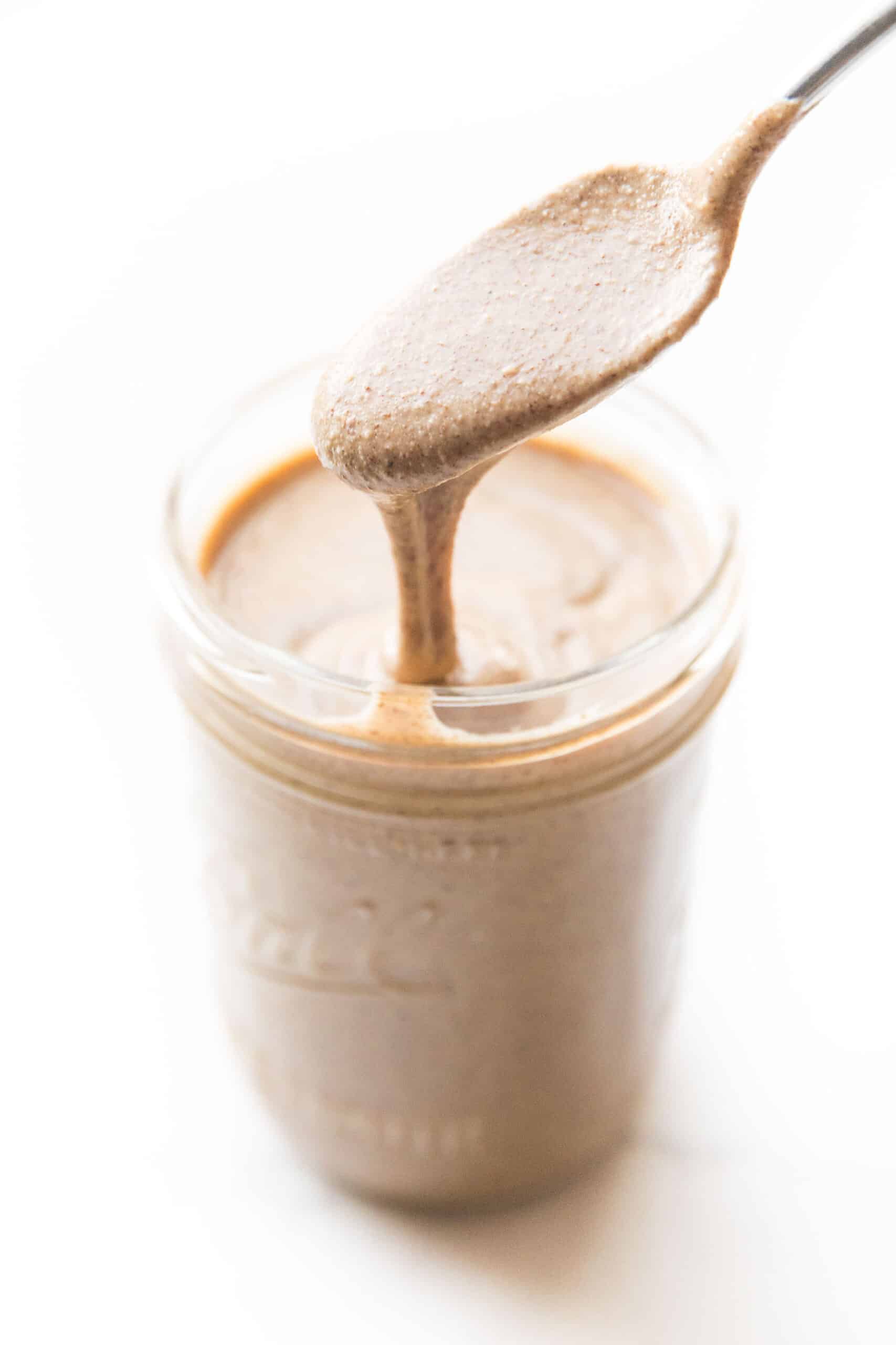 spoon drizzling nut butter in a mason jar