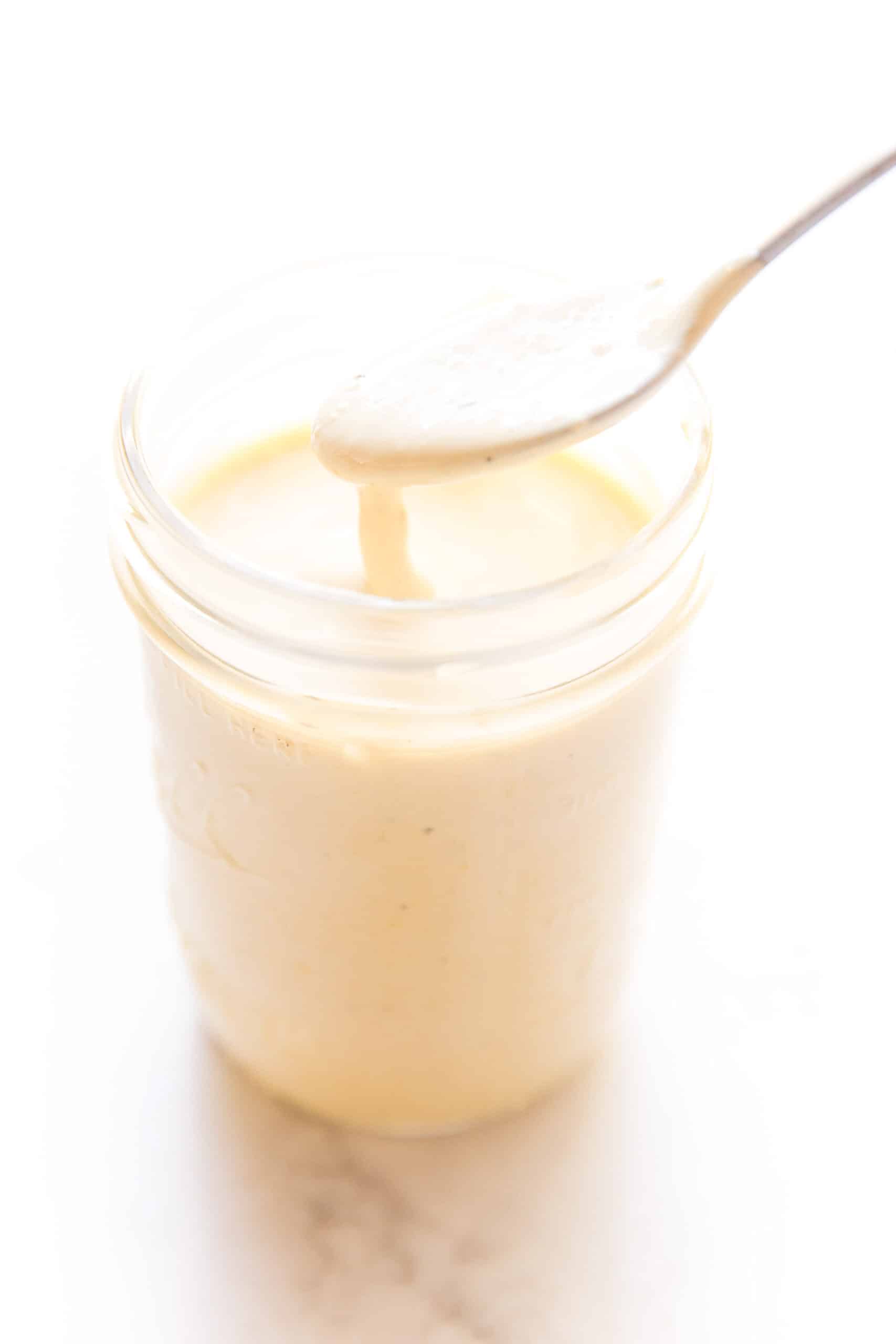 pouring caesar dressing into a mason jar