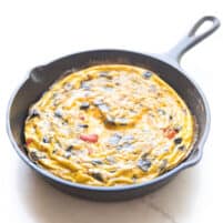 frittata in a cast iron skillet and white background