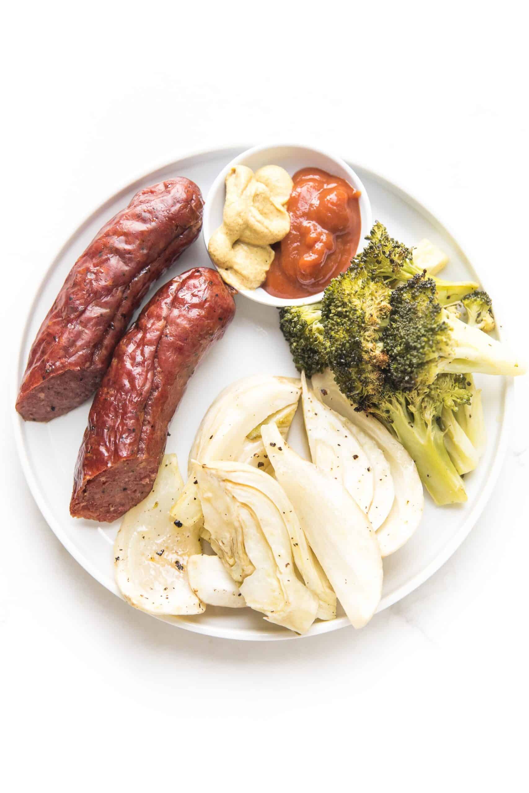 sausage, roasted fennel and broccoli on a white plate and background