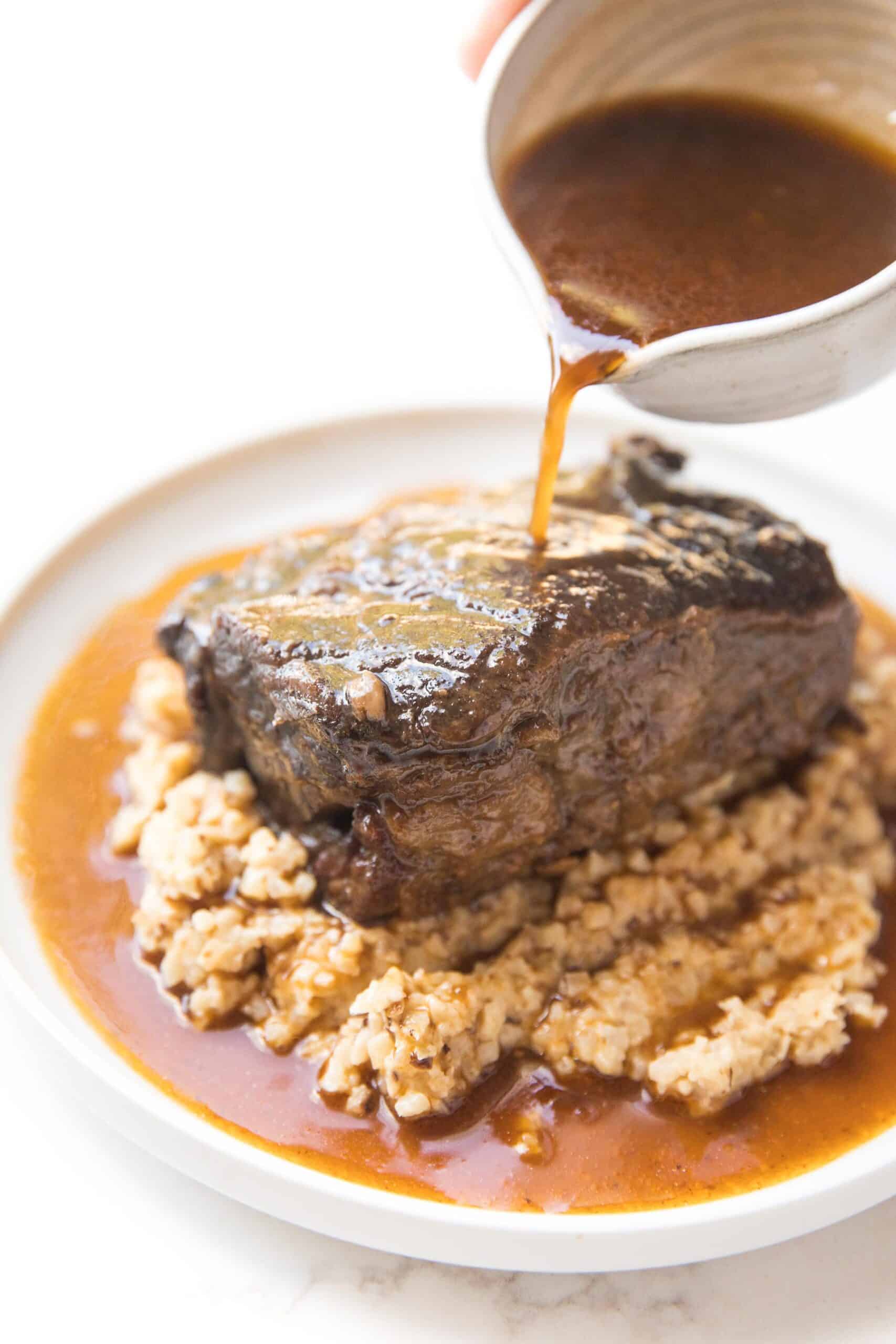 POURING SAUCE OVER SHORT RIBS