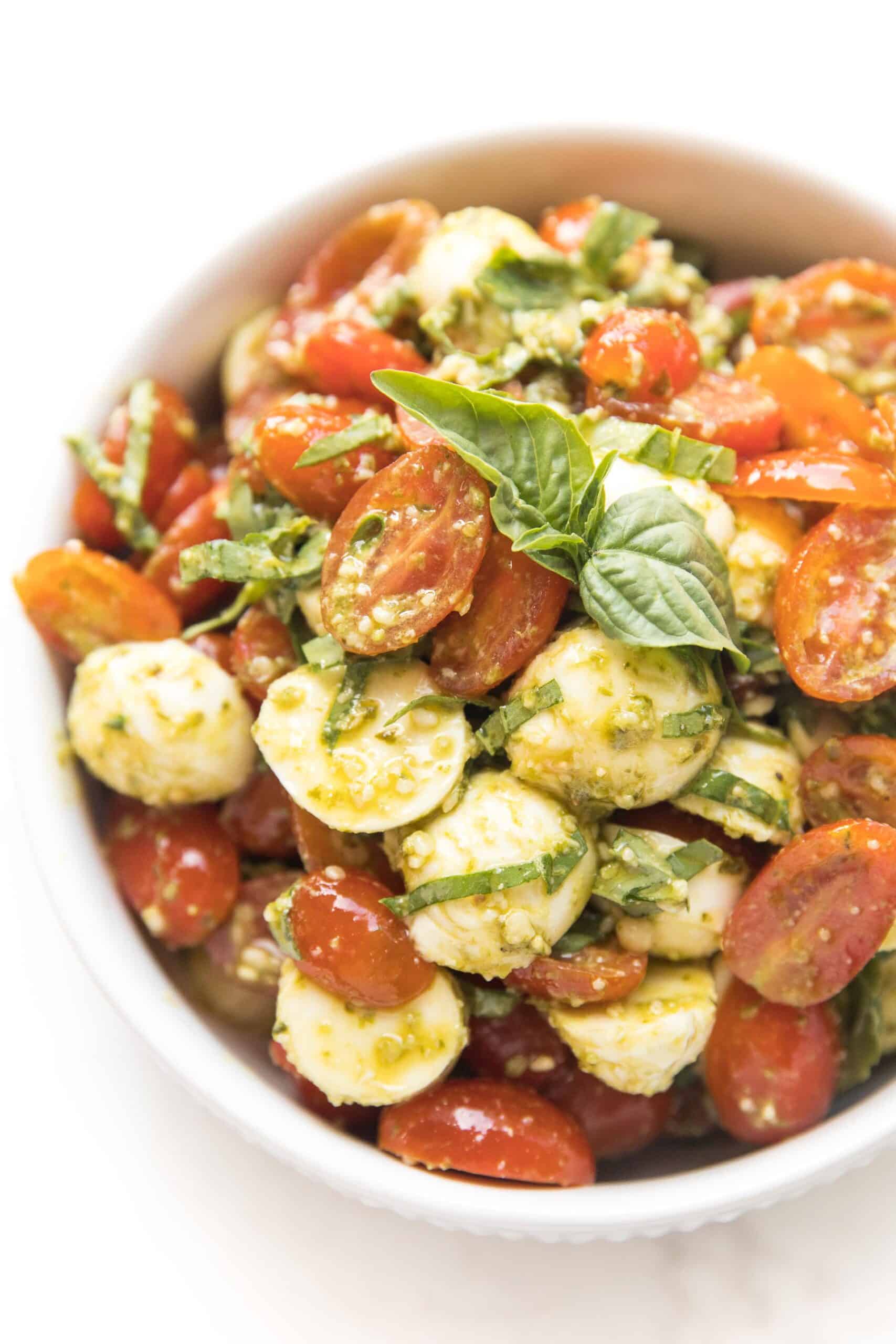 pesto caprese salad in a white bowl