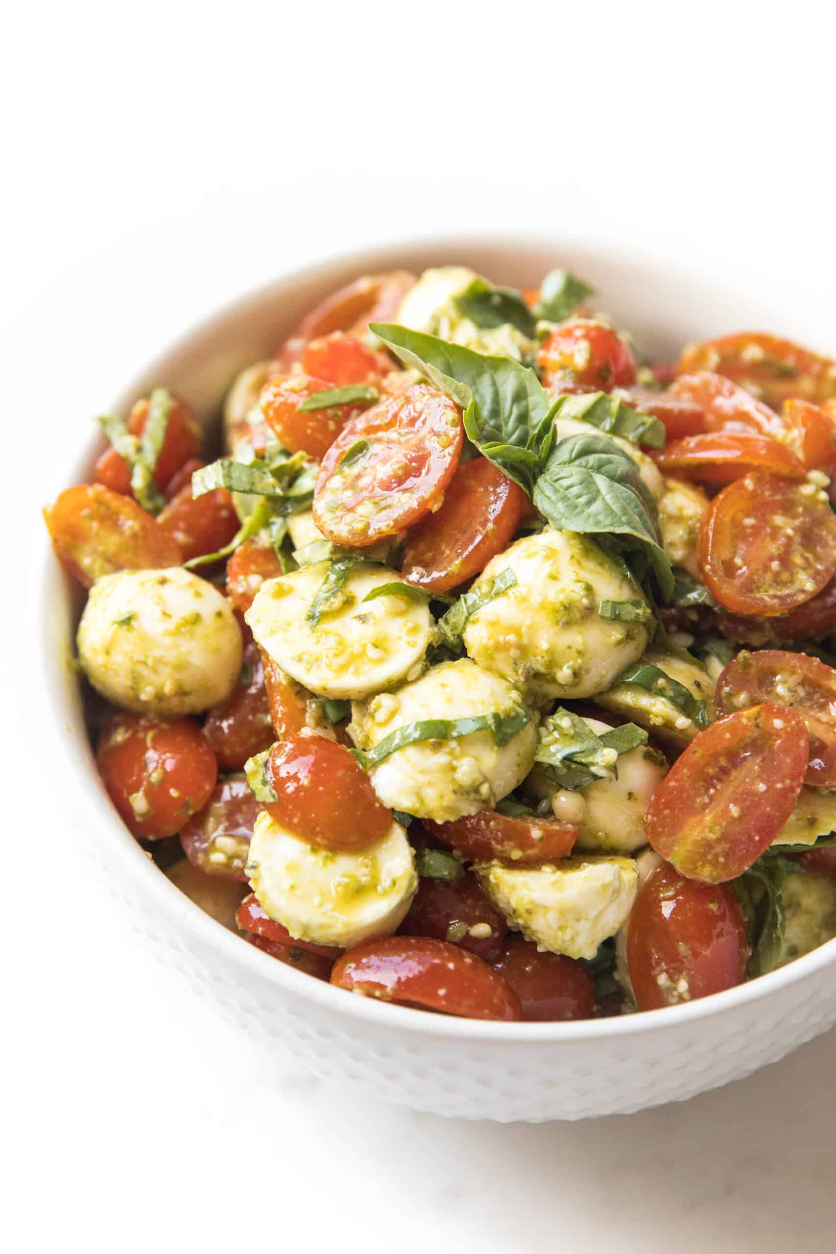 pesto caprese salad in a white bowl