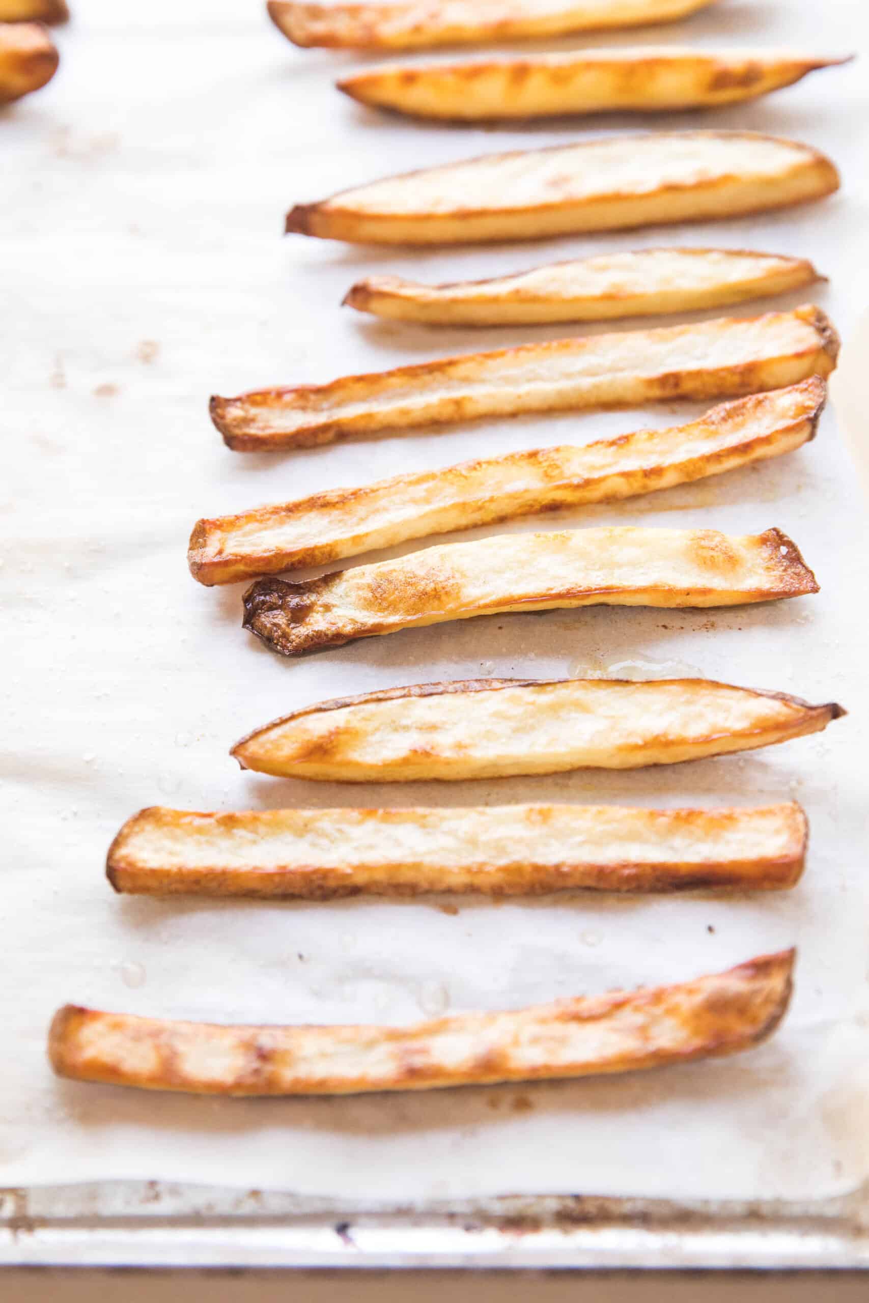 baked french fries on a rimmed baking sheet