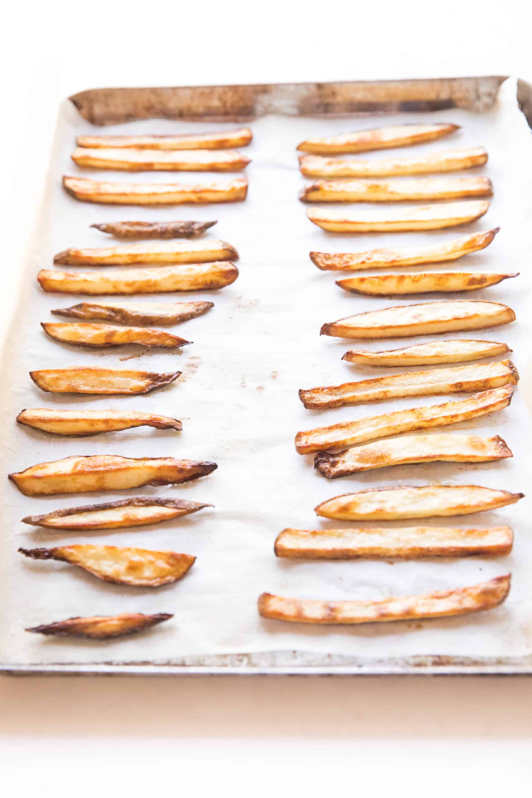 baked french fries on a rimmed baking sheet