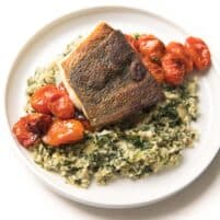 Whole30 + Keto Halibut with Spinach Artichoke Cauliflower Rice Risotto + blistered tomatoes on a white plate