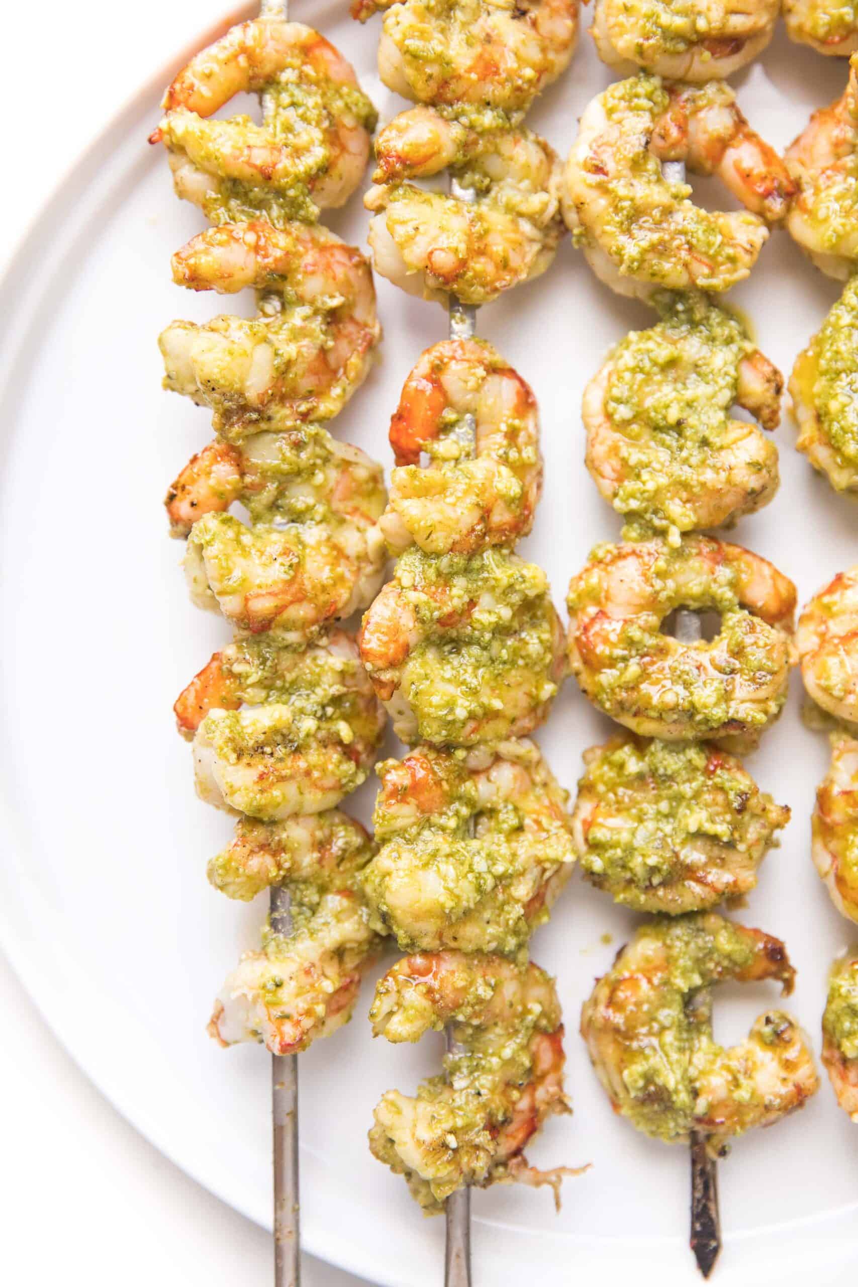 pesto shrimp kabobs on a white plate