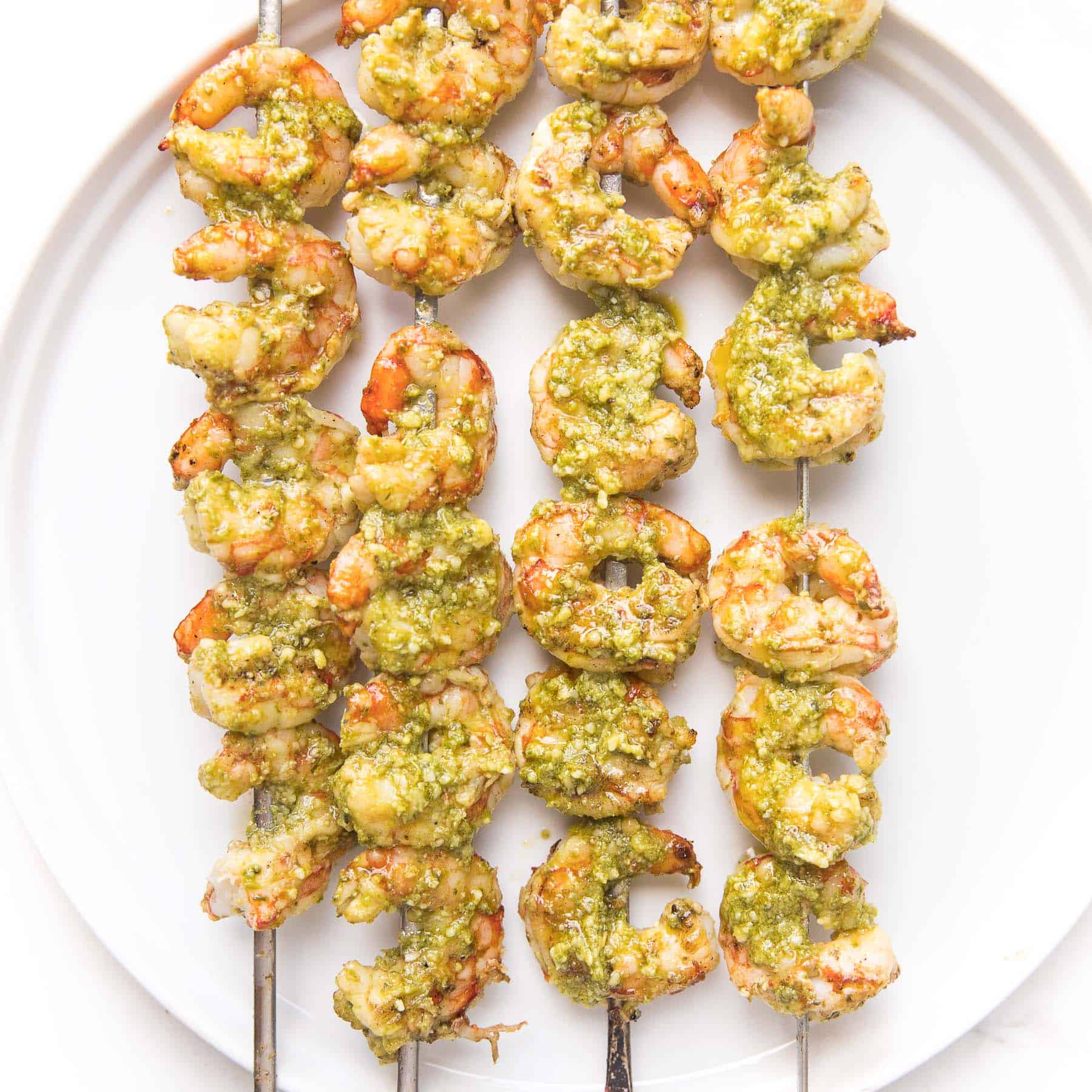 pesto shrimp kabobs on a white plate