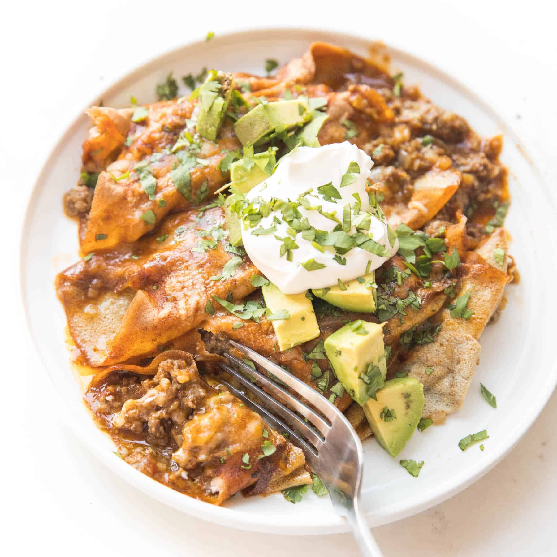 fork cutting in to keto beef enchiladas