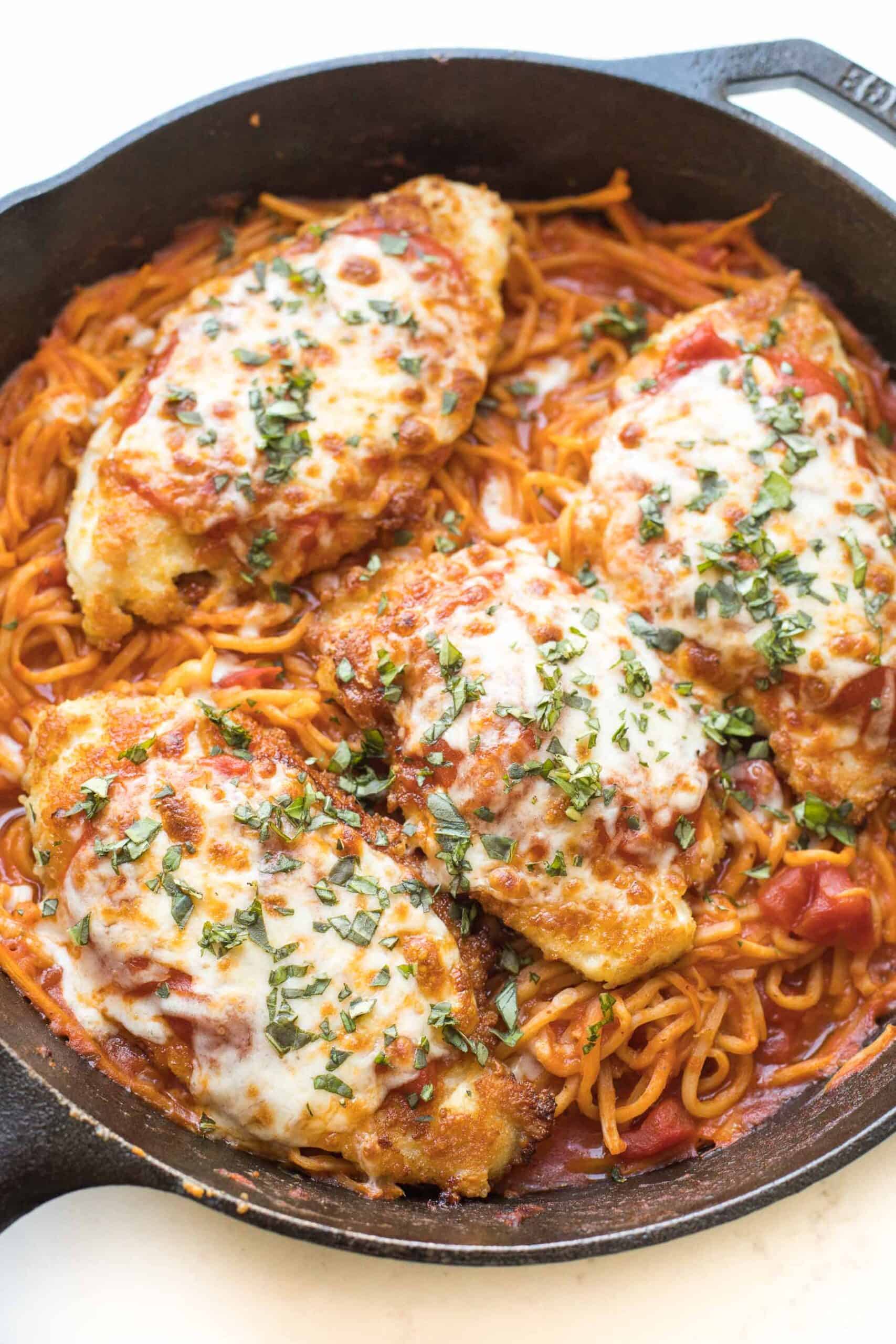 keto skillet chicken parmesan in a cast iron skillet on a white background