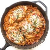 keto skillet chicken parmesan in a cast iron skillet on a white background