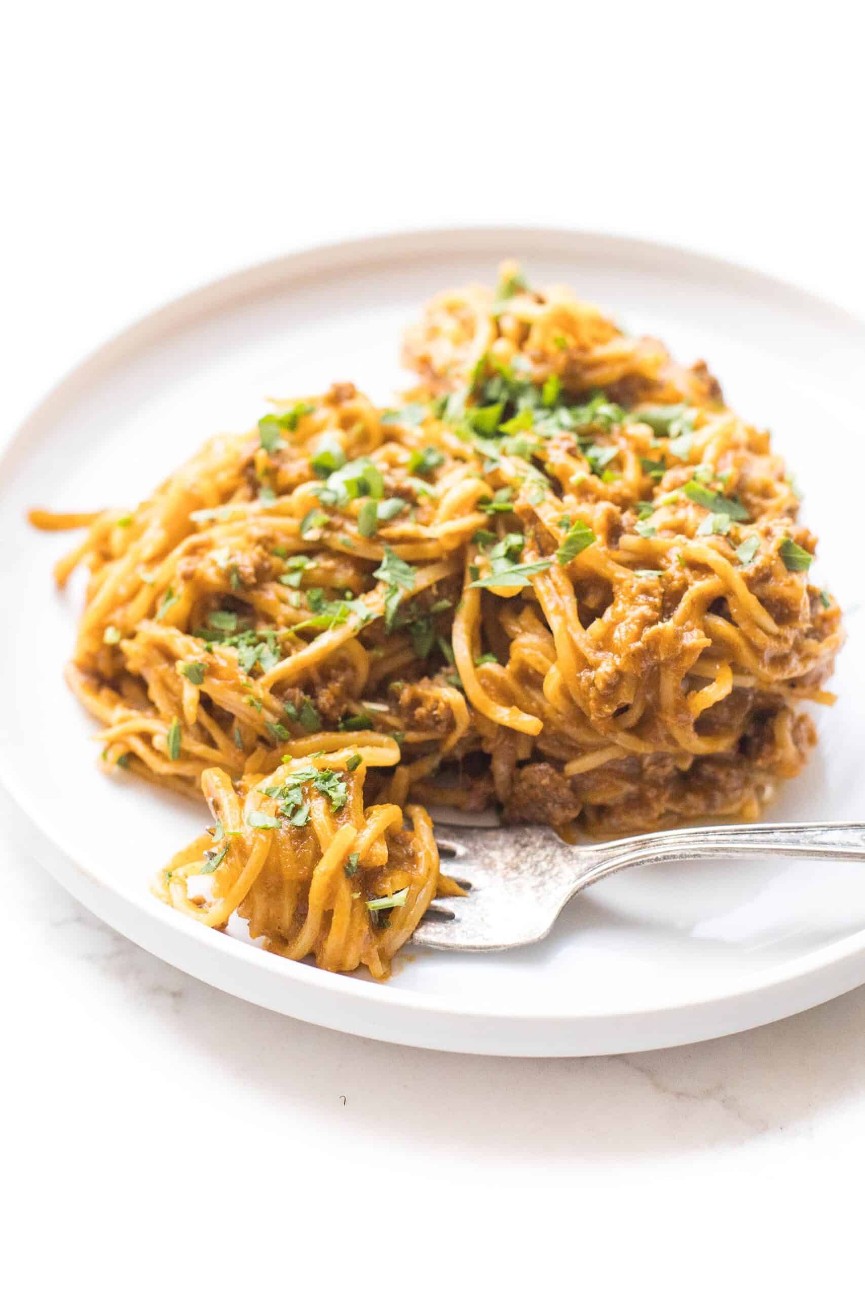 hearts of palm pasta with red meat sauce on a white plate