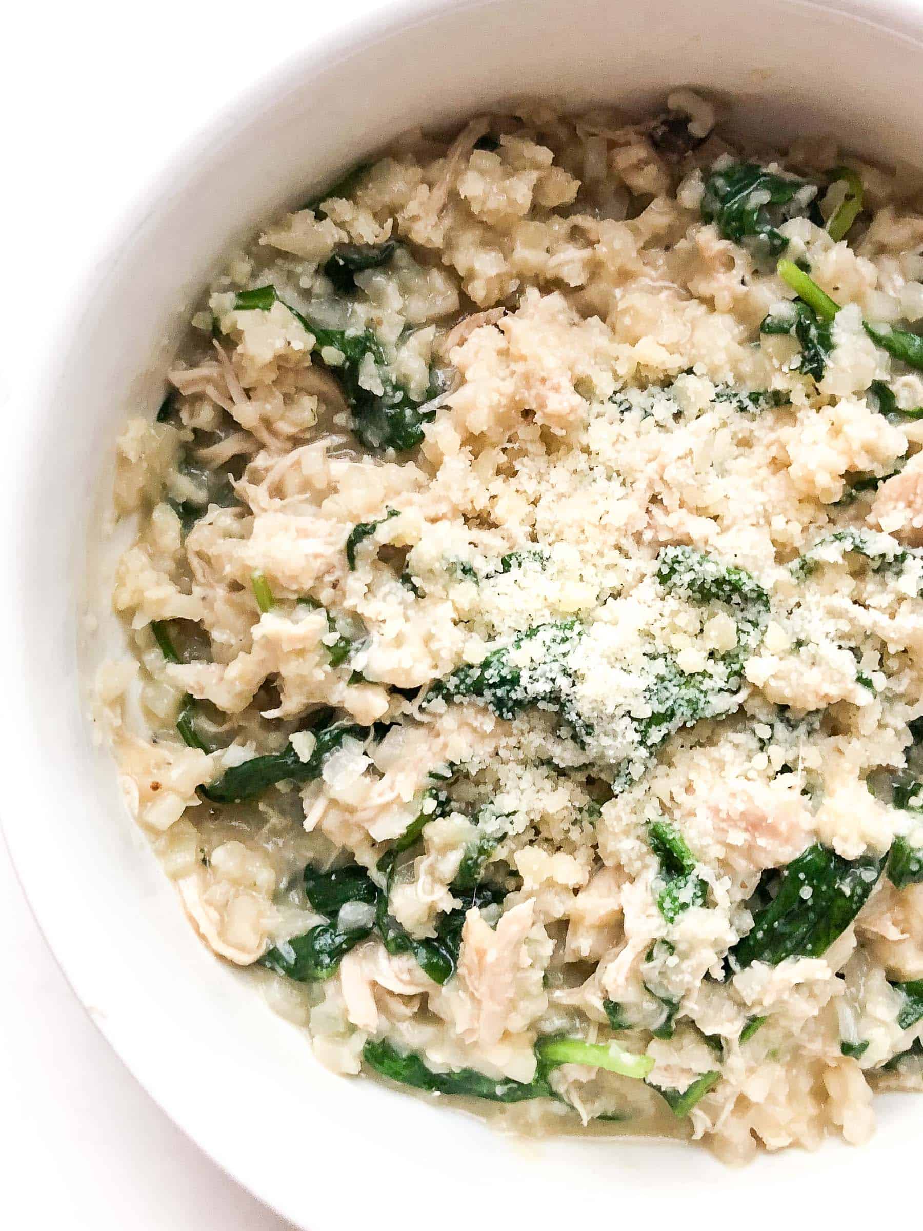 Instant Pot Keto Creamy Mushroom Chicken cauliflower rice Casserole with spinach and parmesan in a white bowl