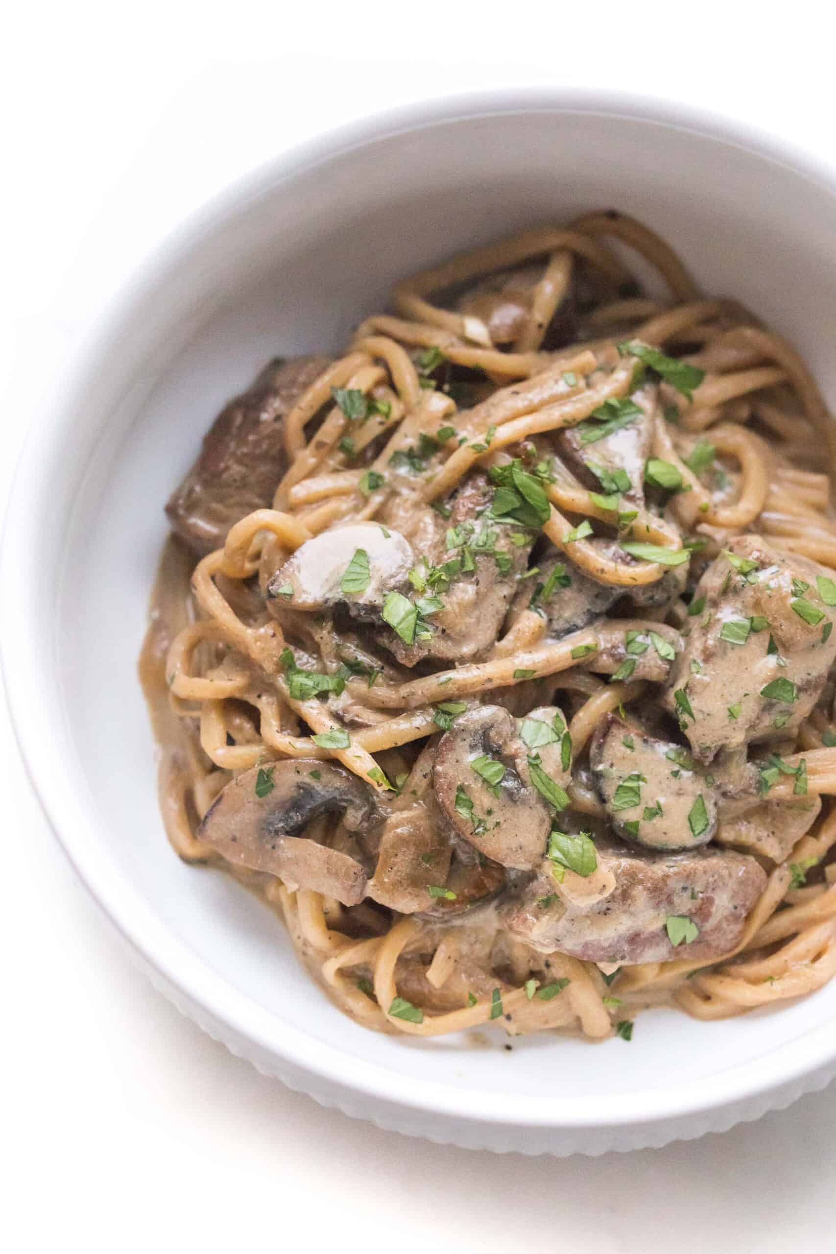 keto beef stroganoff in a white bowl on a white background