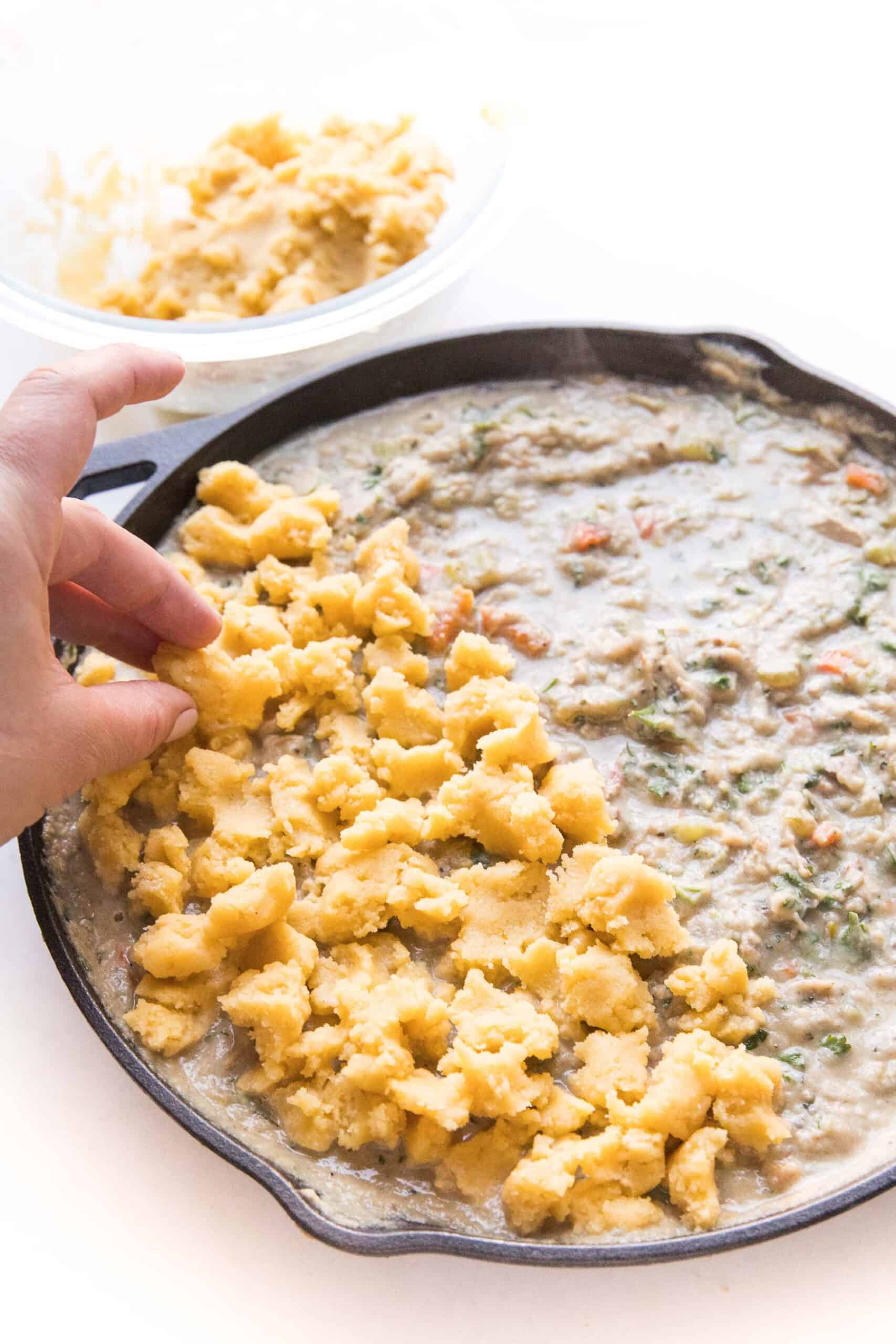 keto chicken pot pie crumble in a cast iron skillet on a white background