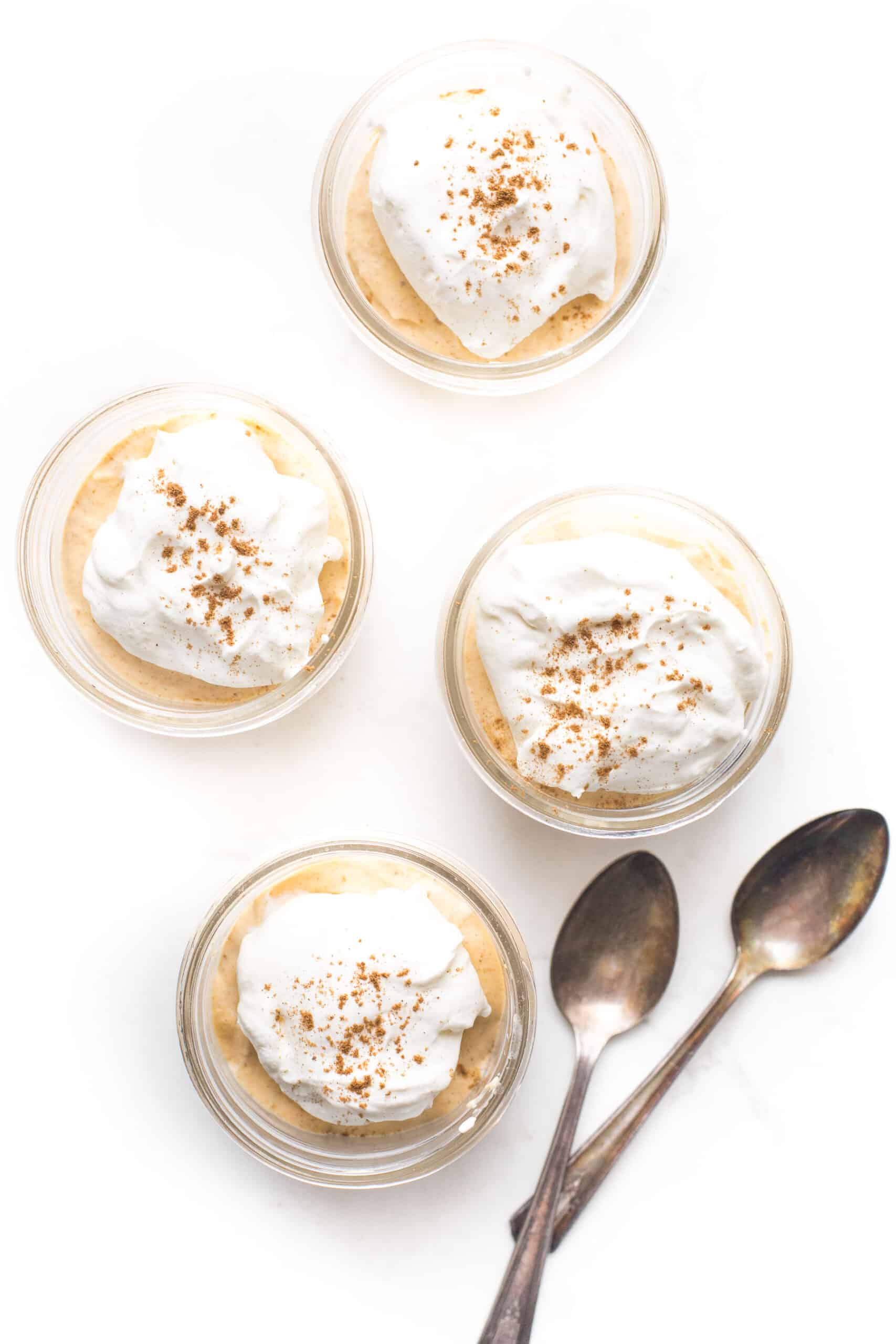 low carb mini pumpkin cheesecakes in a mason jar with whipped cream and pumpkin pie spice