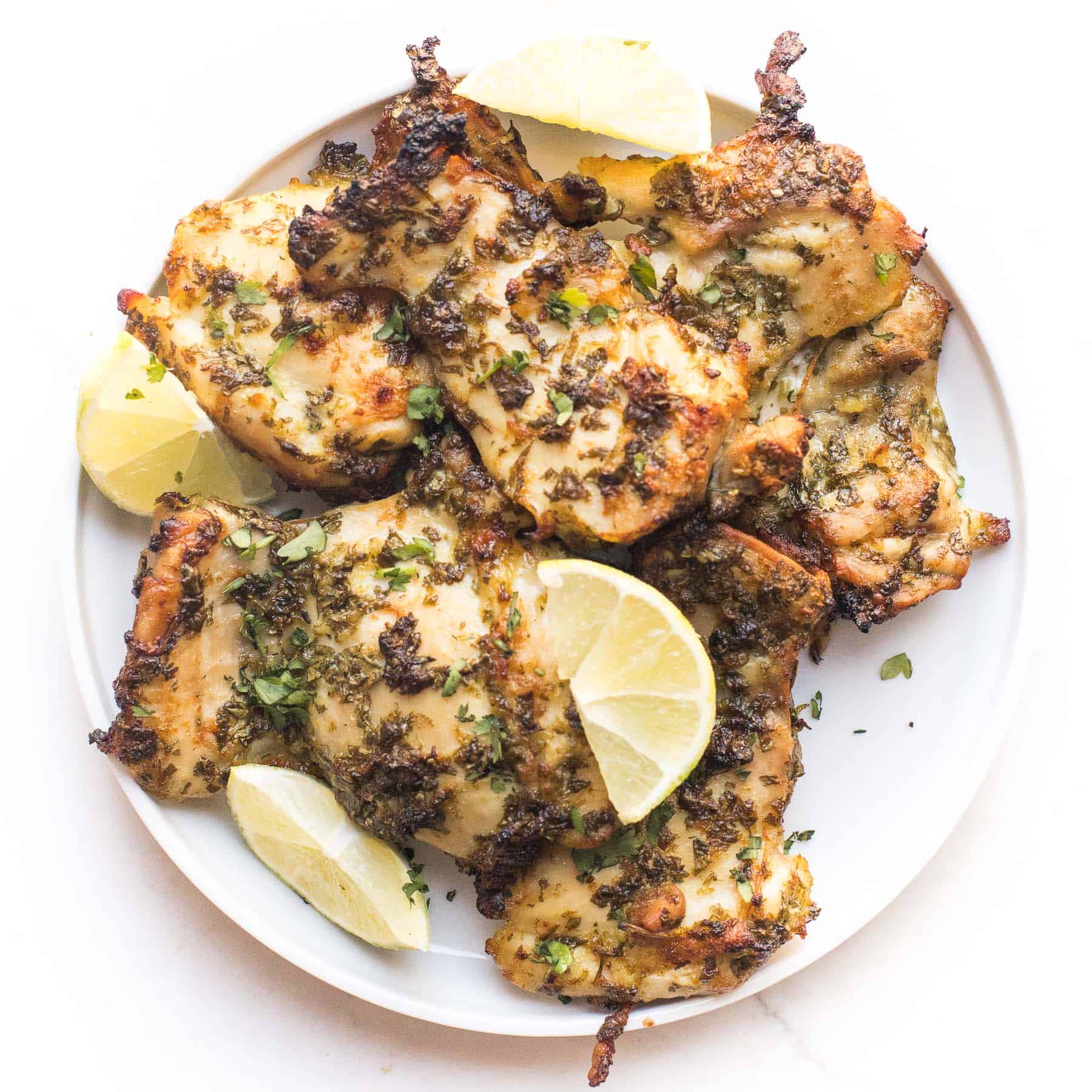 keto cilantro lime chicken thighs on a white plate and background