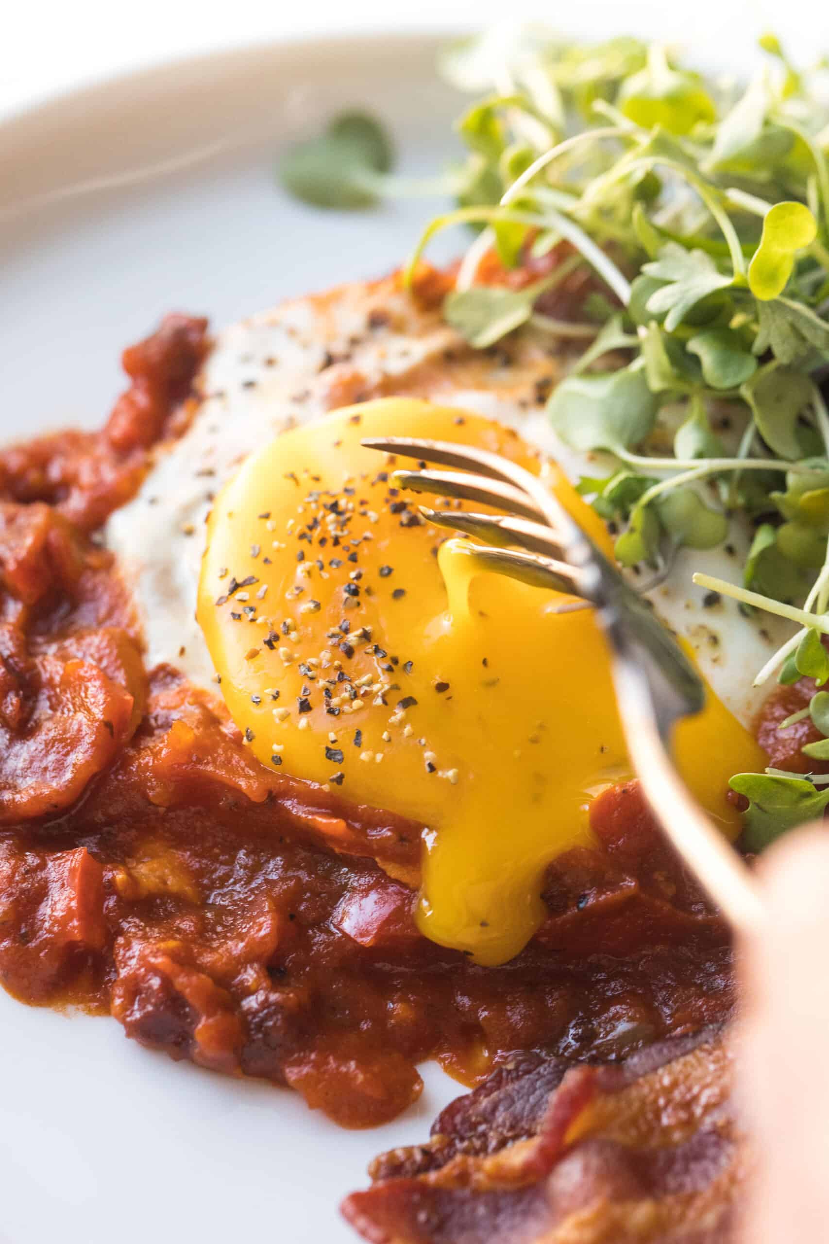 KETO SHAKSHUKA EGGS IN TOMATO SAUCE ON A WHITE ON A WHITE BACKGROUND