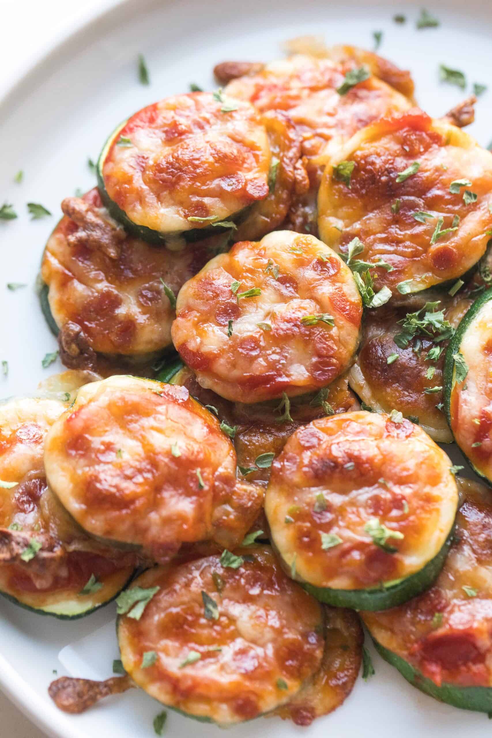 keto mini zucchini pizza bites on a white plate and background