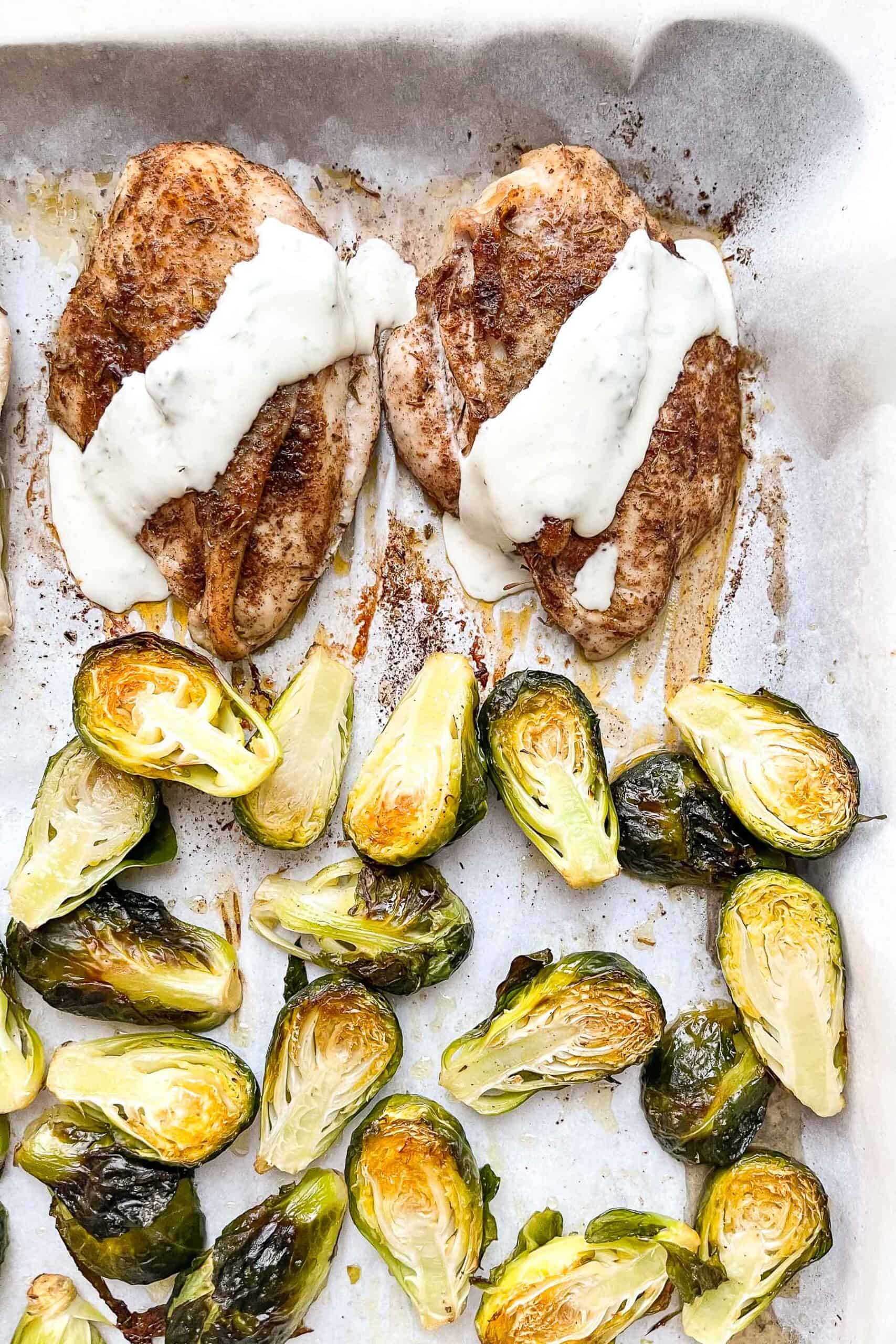 jerk seasoned chicken on a sheet pan with brussels sprouts