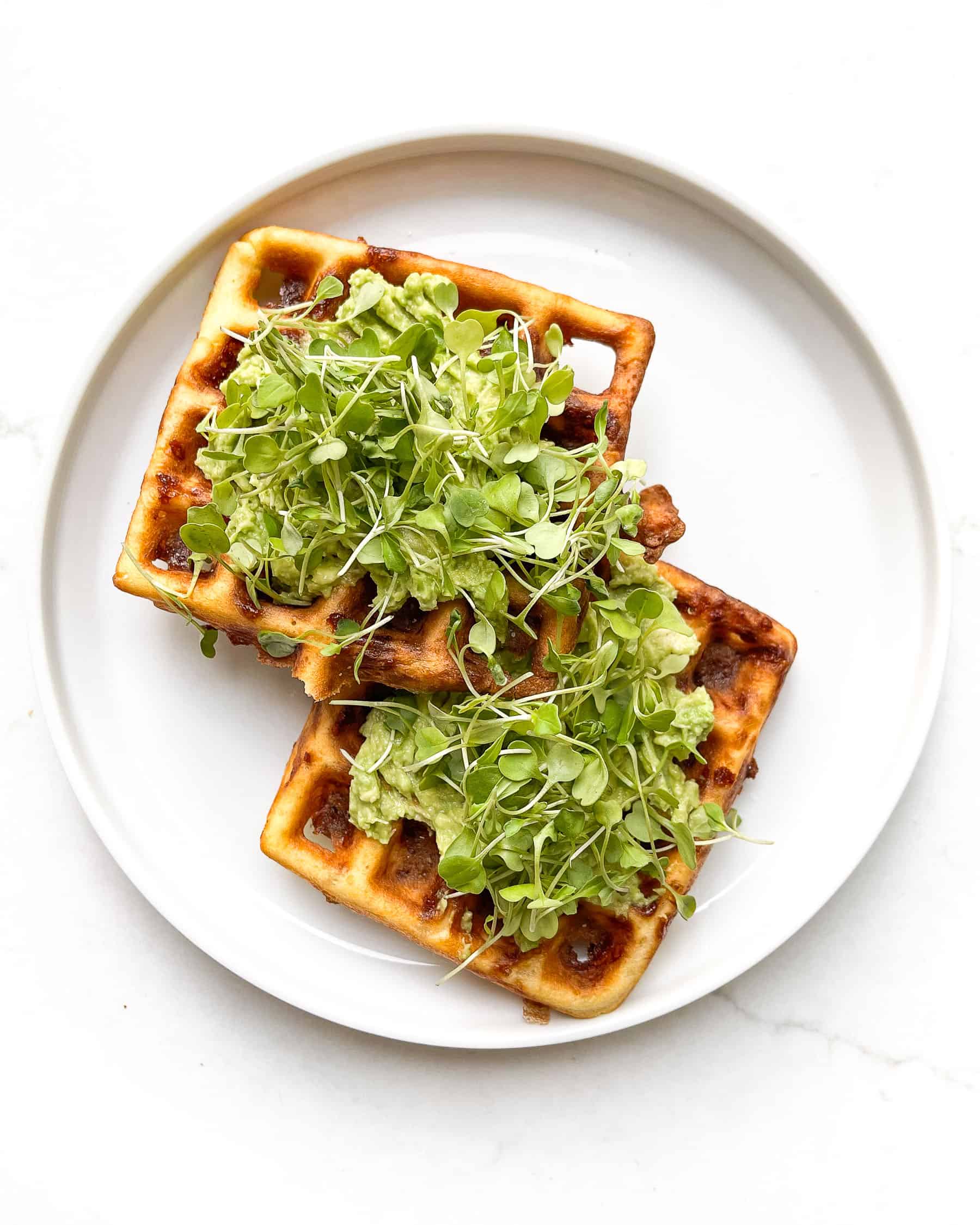 3 ingrdient chaffle topped with mashed avocado and microgreens