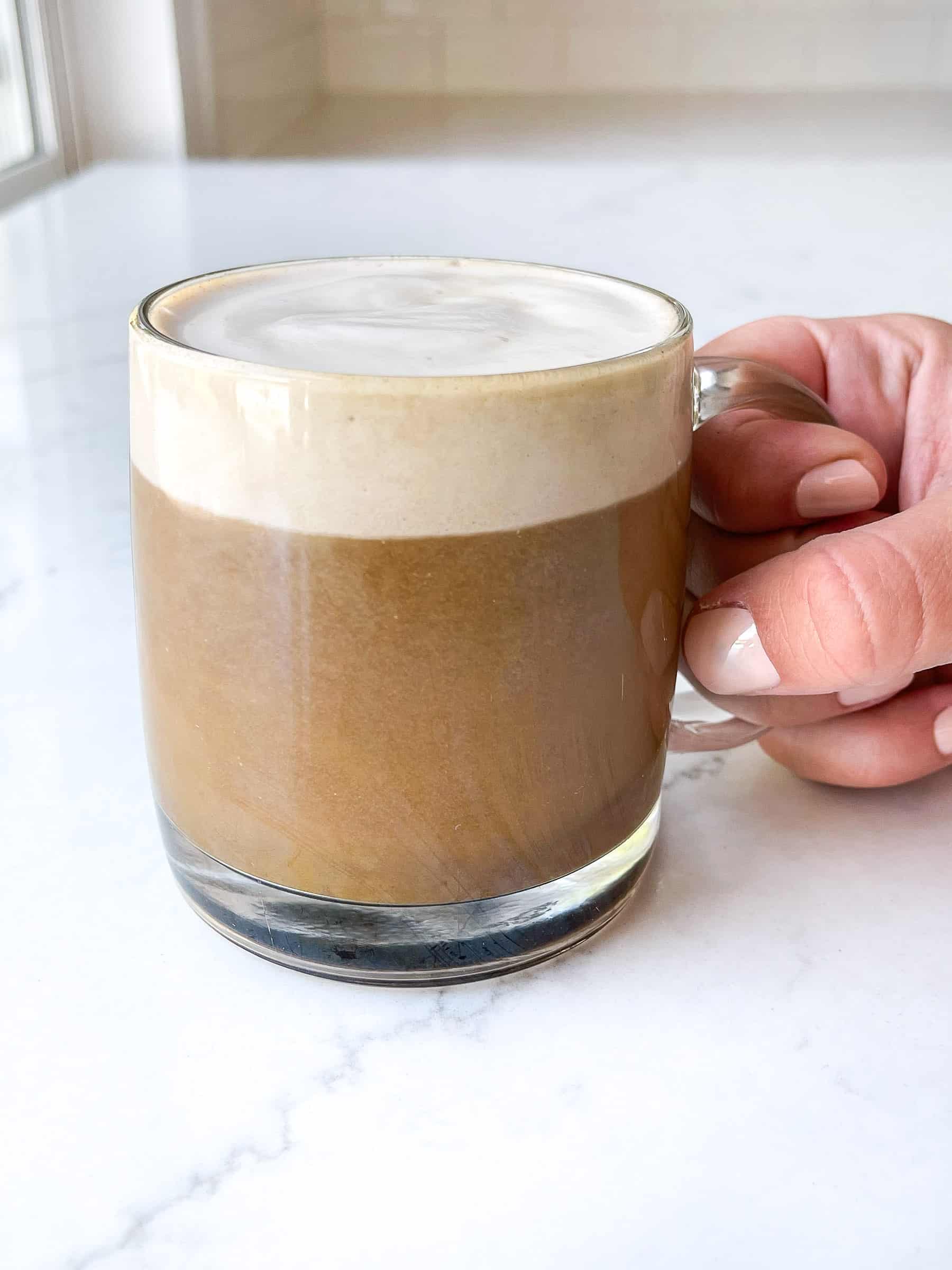 hand holding a latte coffee