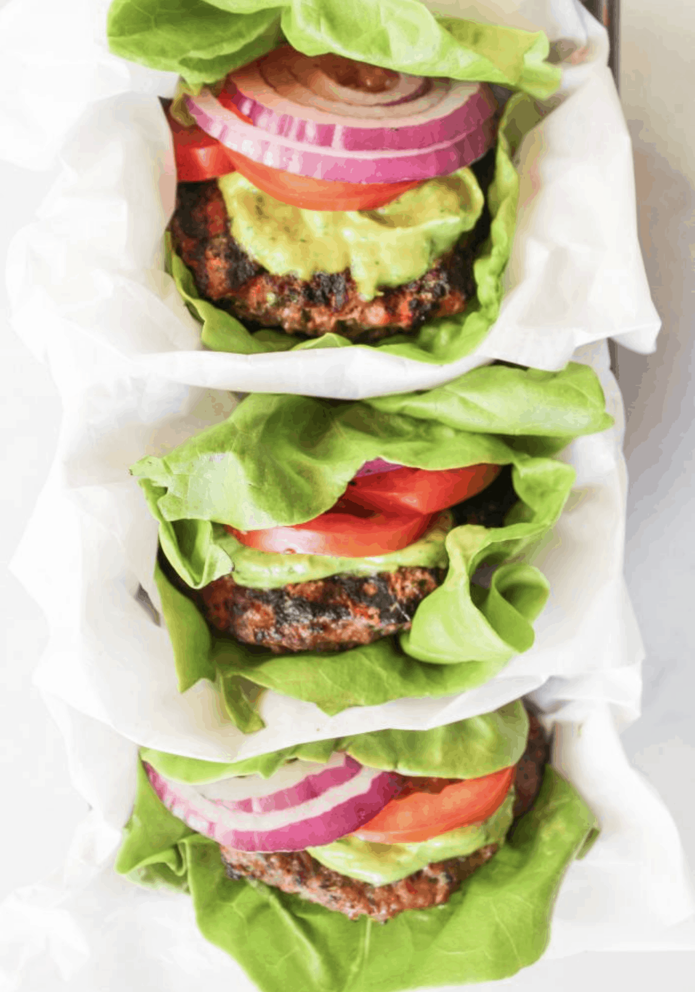 three types of burgers all wrapped in lettuce buns