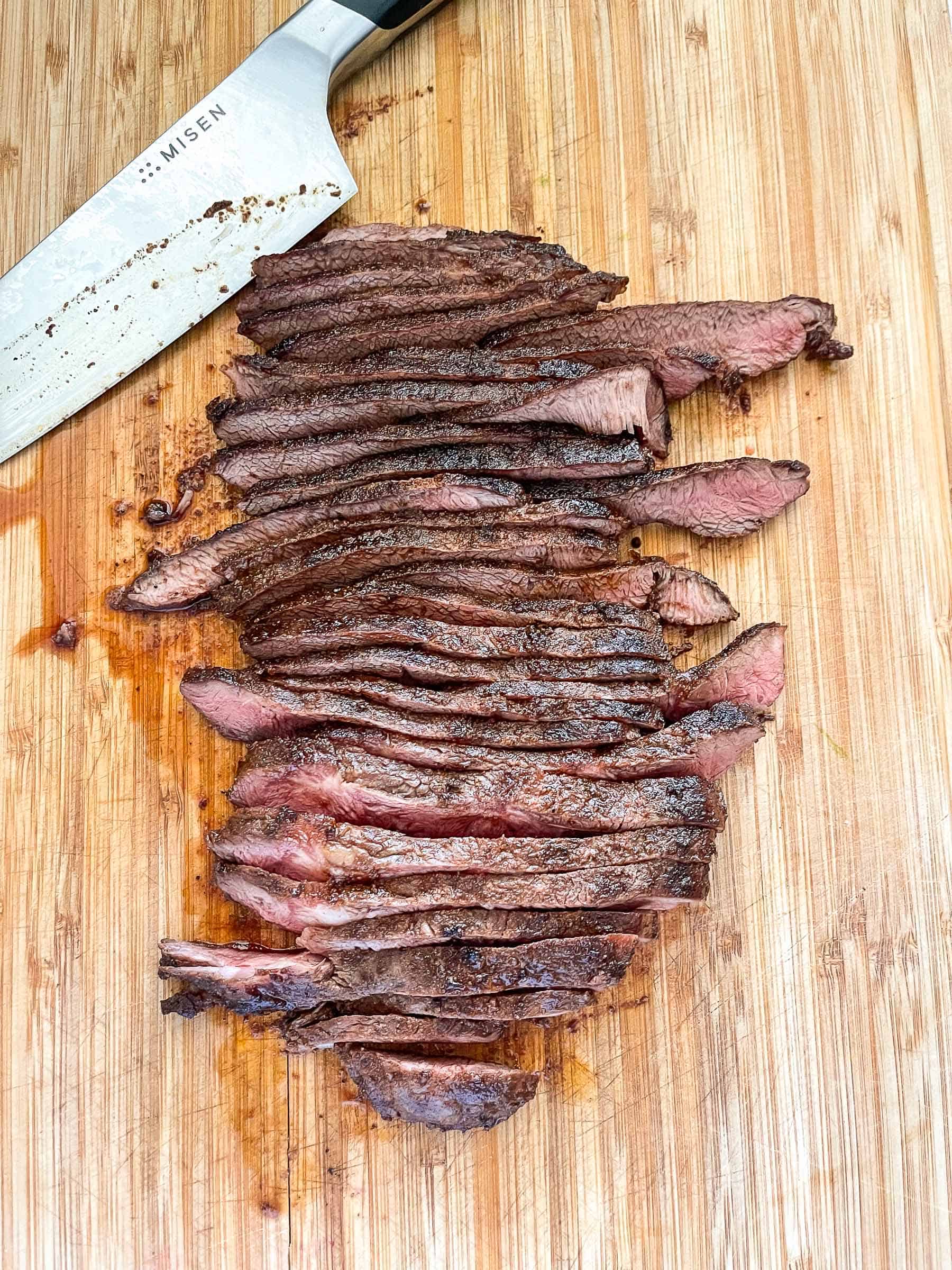 sliced flat iron stake on a cutting board