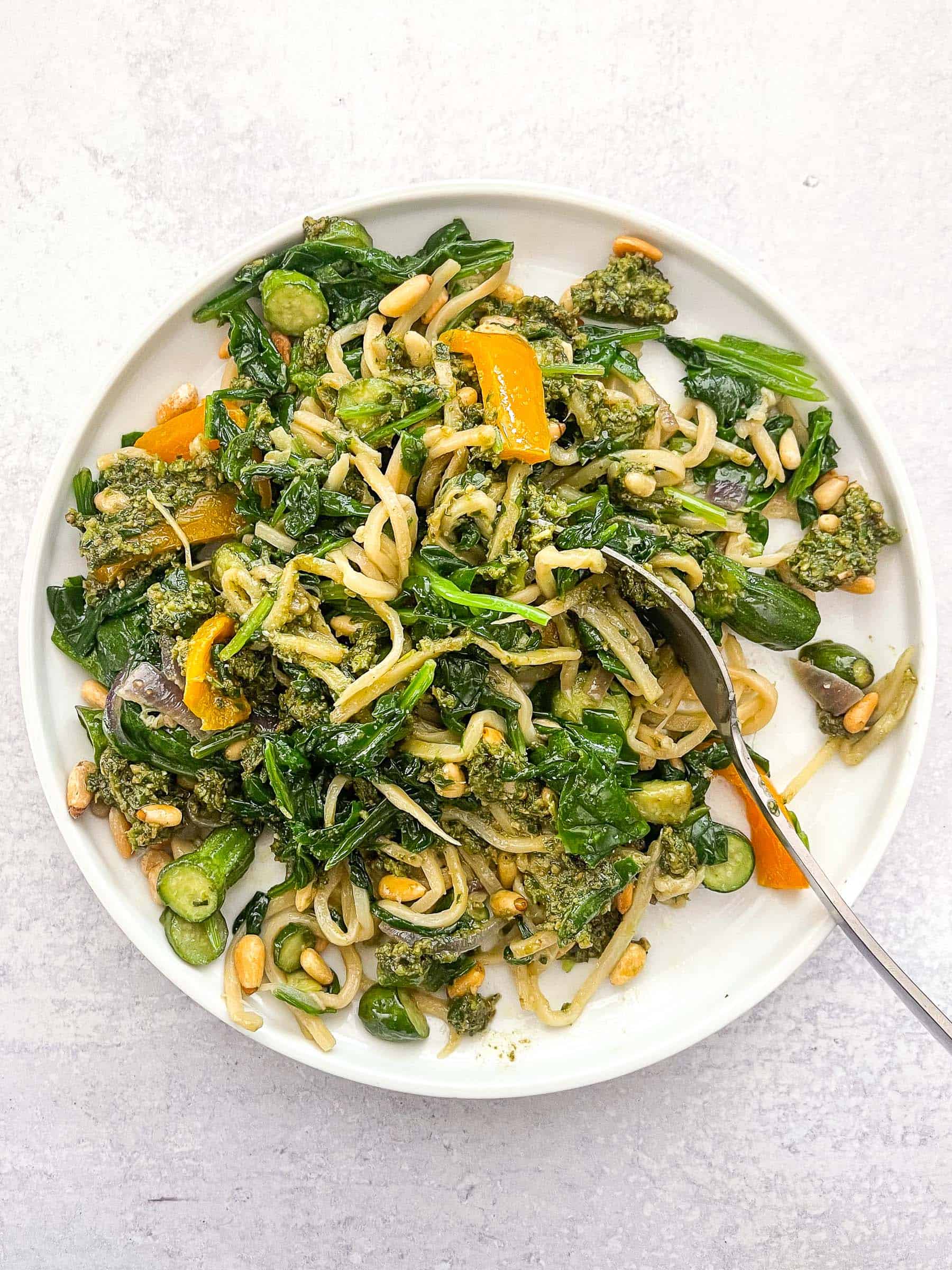 keto summer pasta with pesto on a white plate and background with a silver spoon