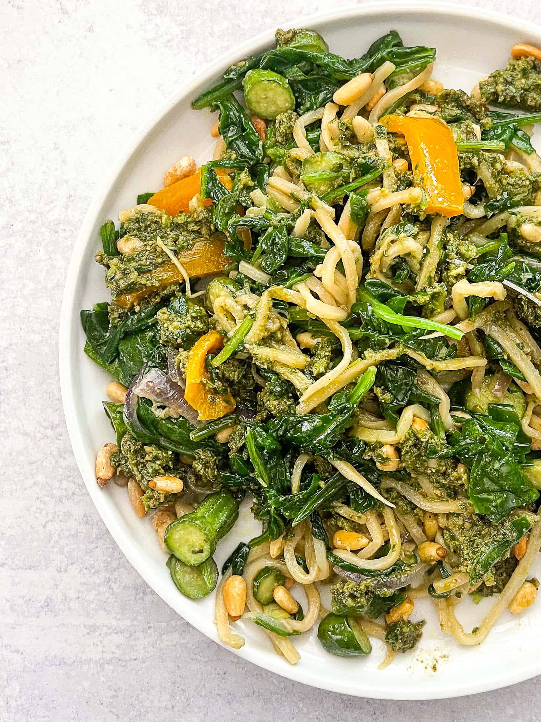 keto summer pasta with pesto on a white plate and background with a silver spoon