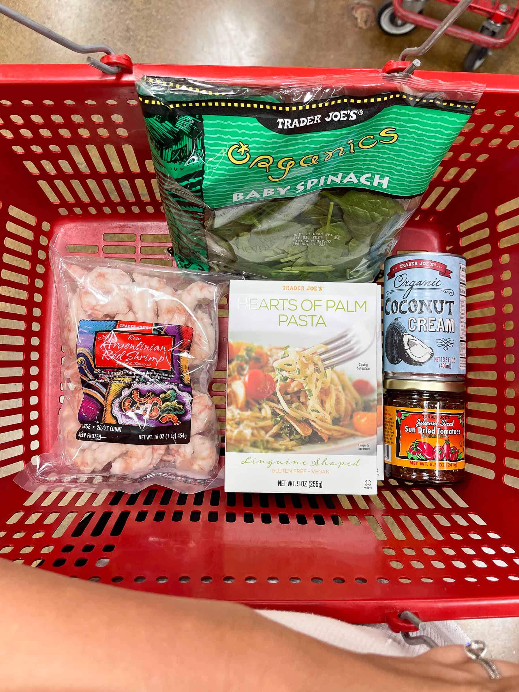 ingredients for keto creamy tuscan shrimp pasta in a red trader joe's basket