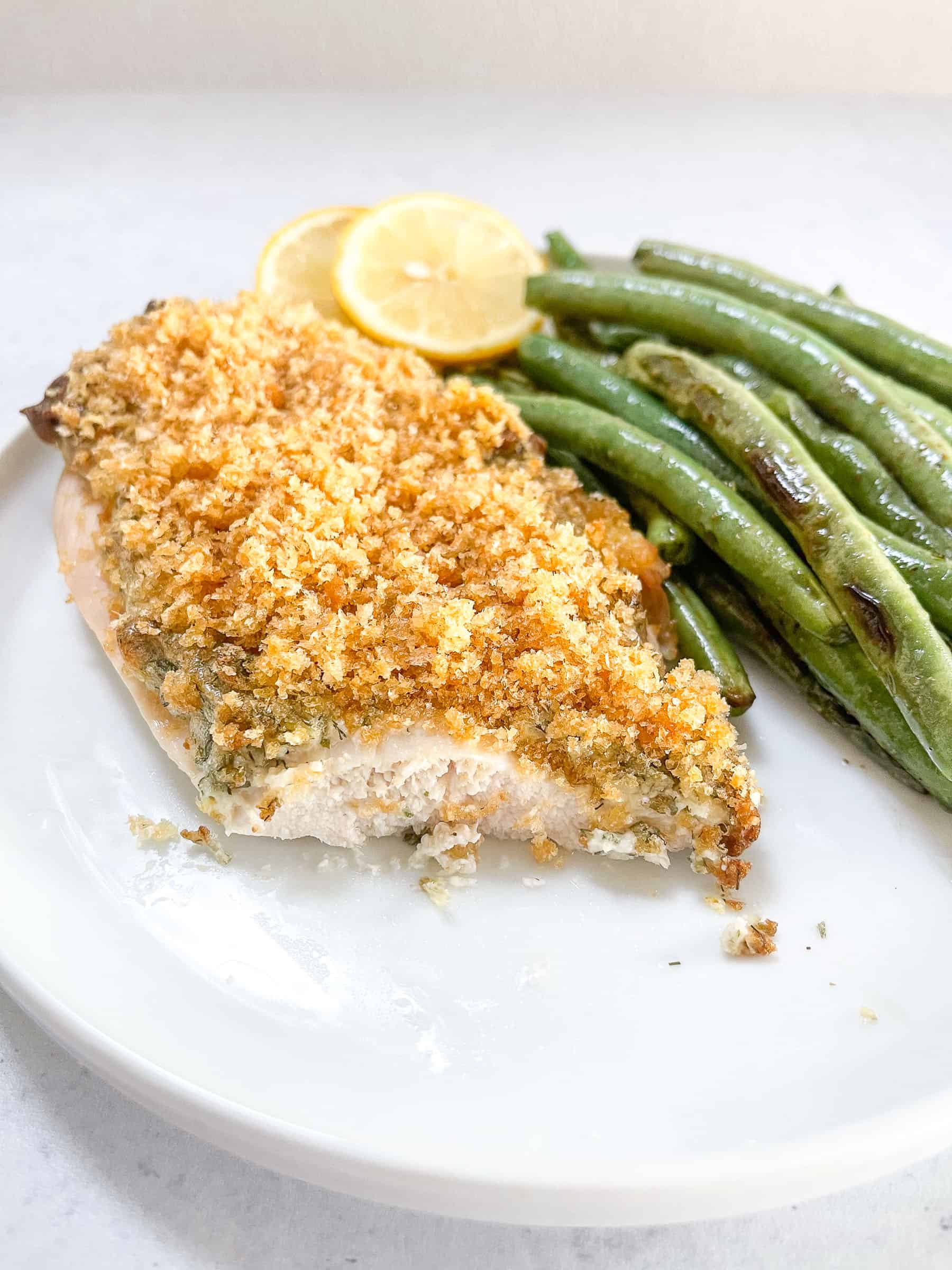 keto crispy ranch chicken with green beans and lemon garnish on a white plate with a white background