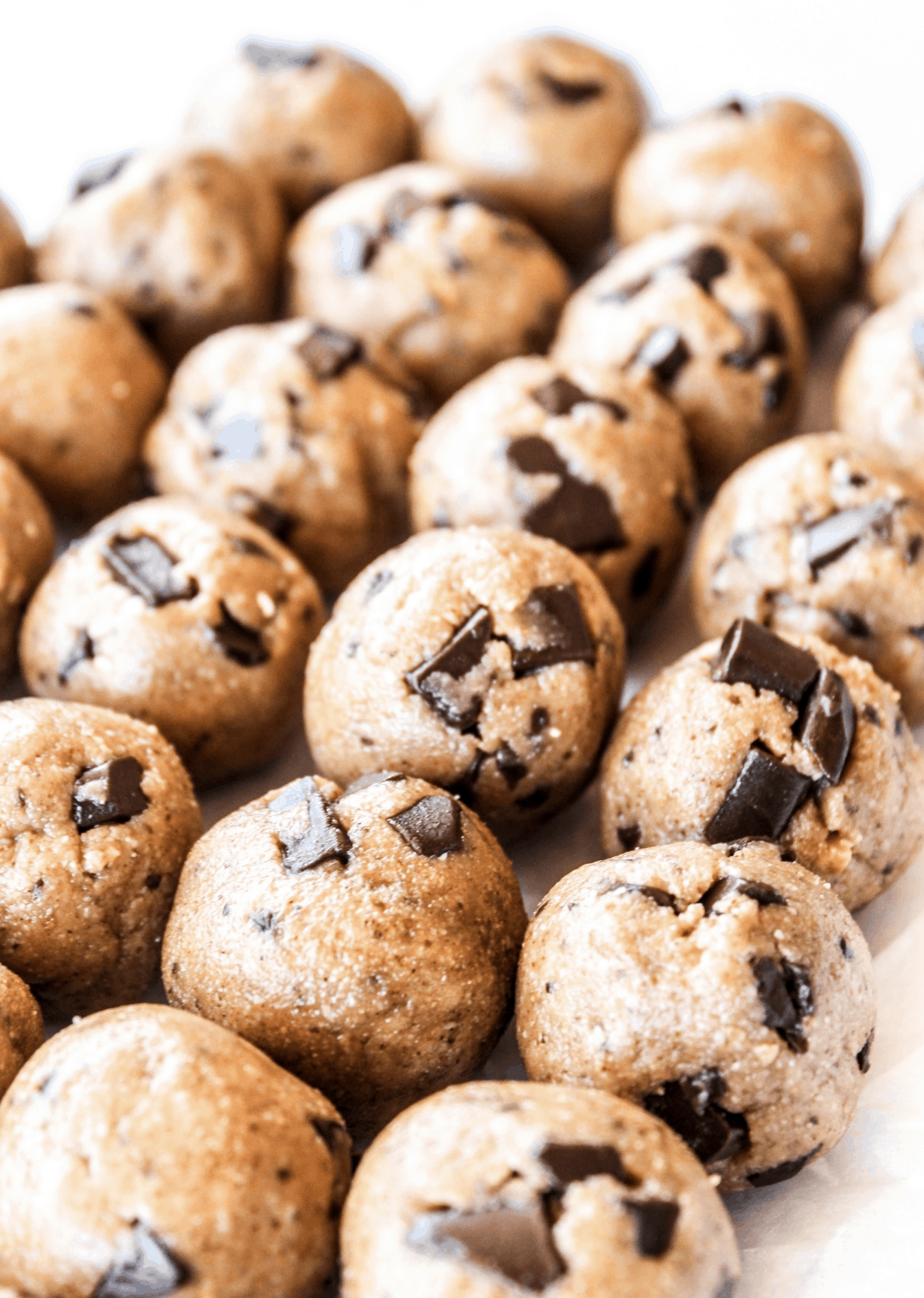 rows of cookie dough shaped balls all line up next to each other