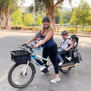 four people on a family cargo bike