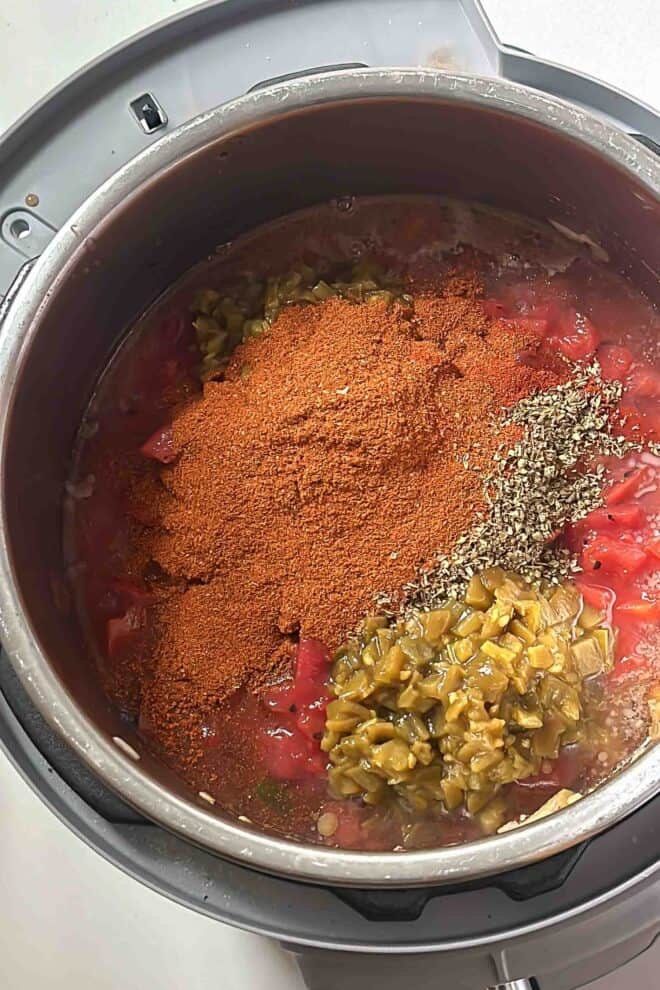 spices on top of ground meat and veggies in a pot