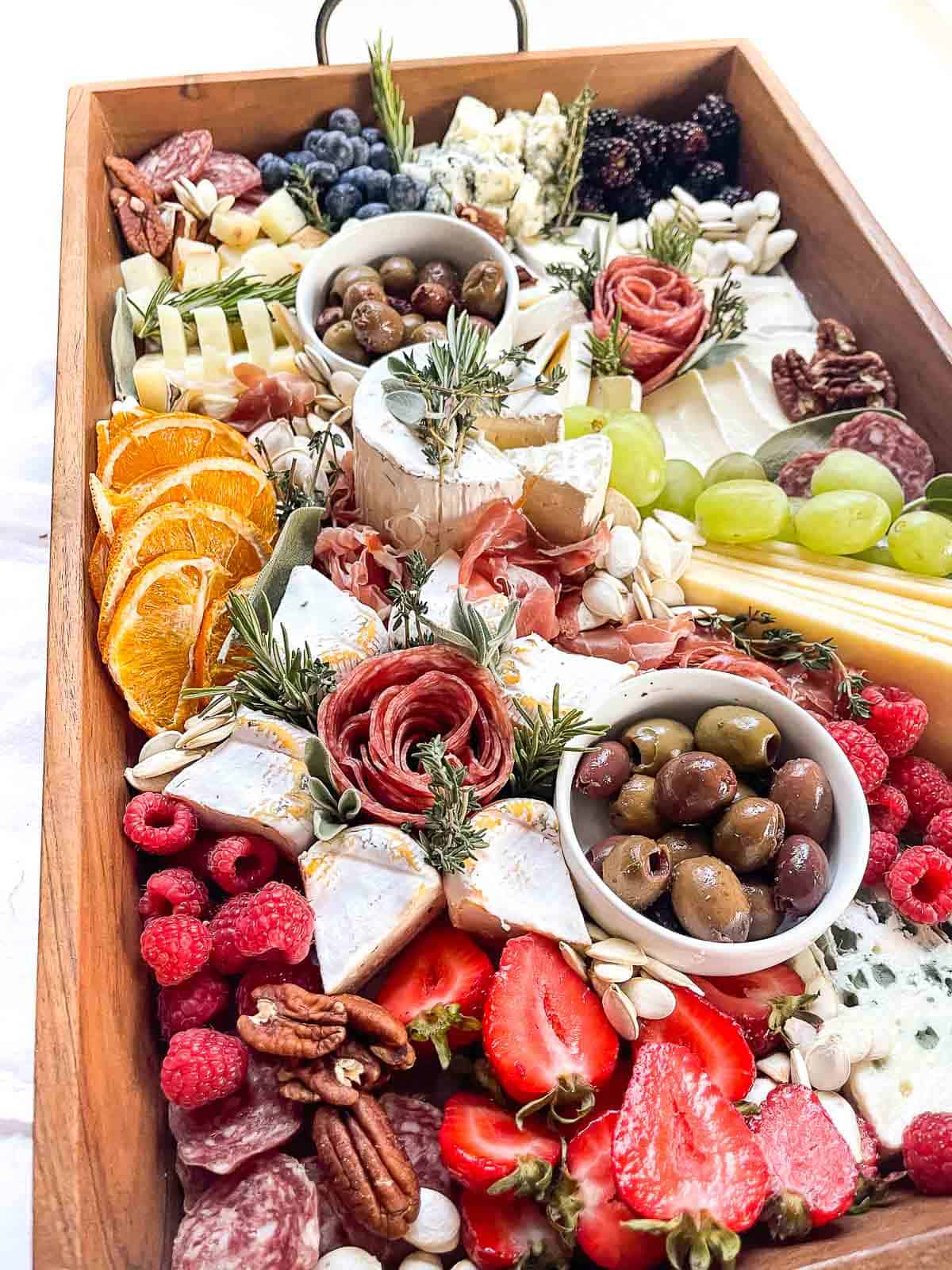 close up shot of a styled christmas charcuterie board with cheeses, meats, fruit and nuts.