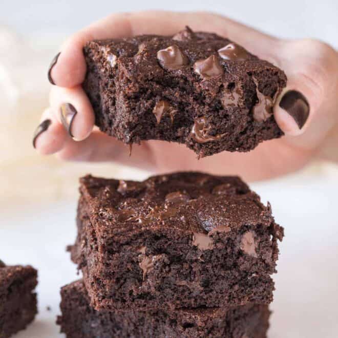 Hand holding brownies with chocolate chips