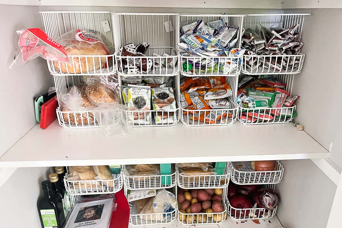 white wire baskets stacked and filled with snacks in an organized pantry