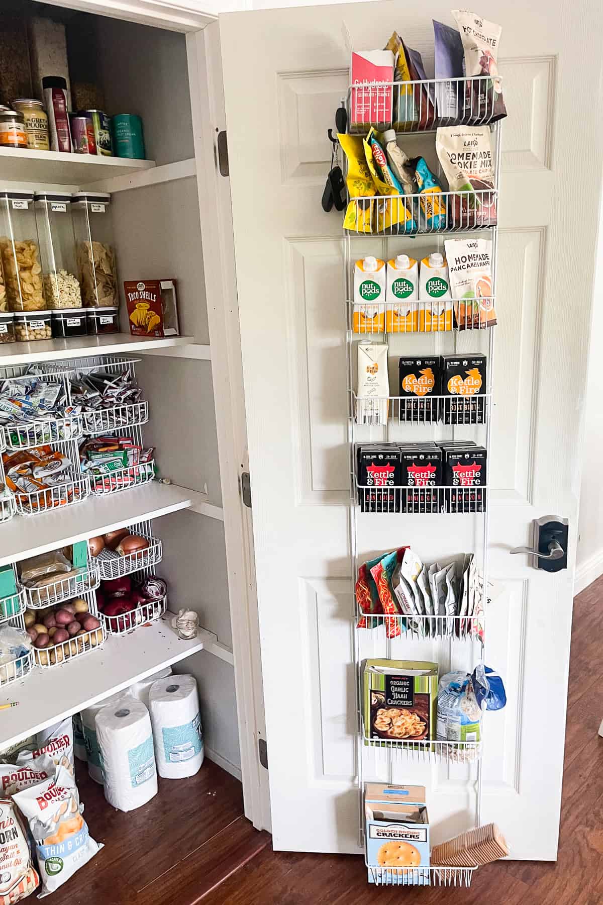 pantry door open with a wire rack door organizer, filled with pantry food