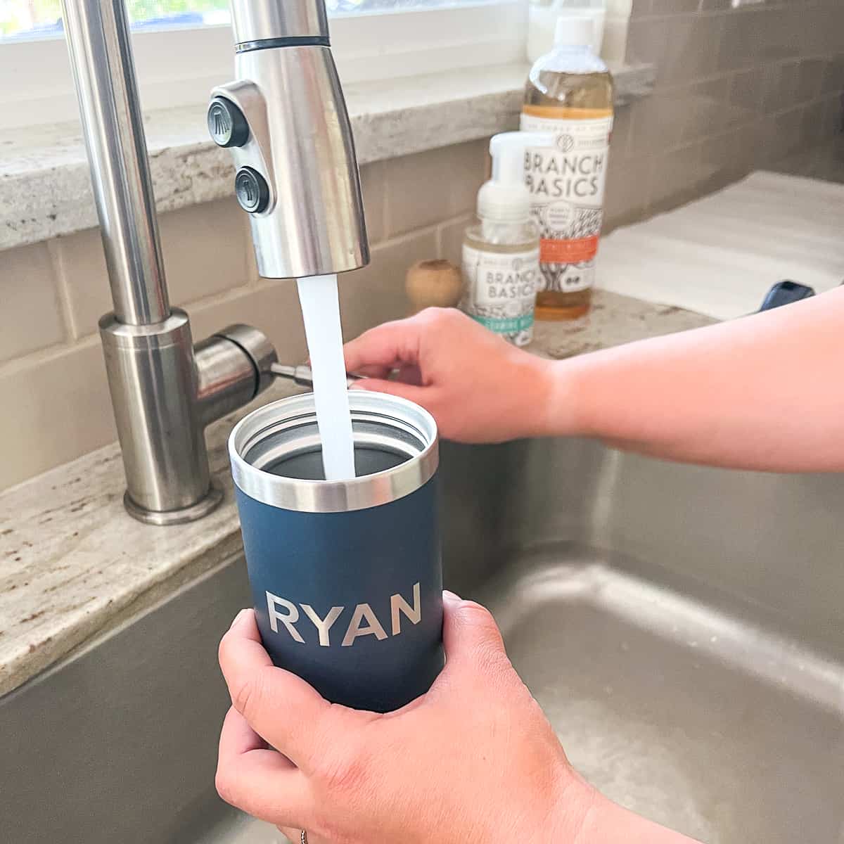 cleaned water bottle getting filled with water at the sink