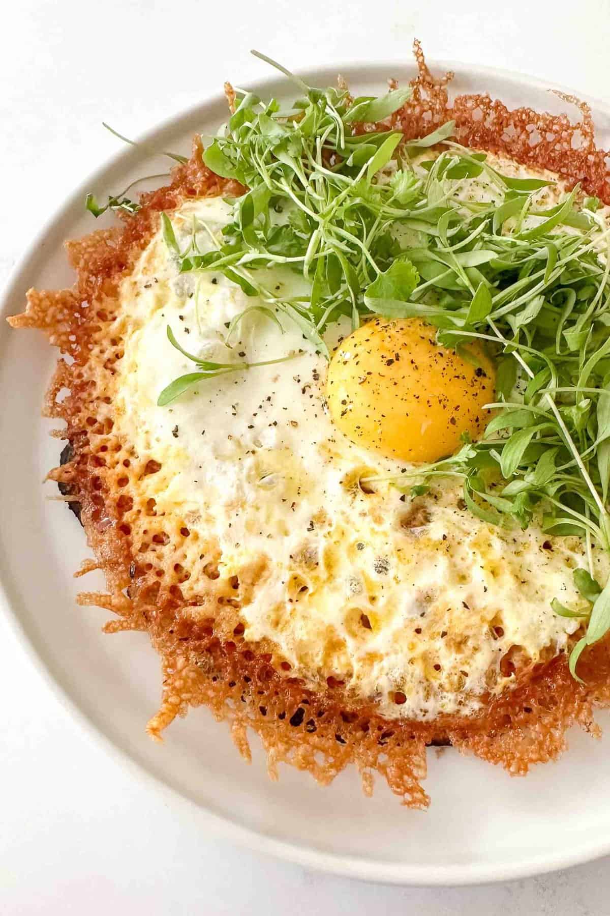 a close up photo of a crispy fried egg taco topped with microgreens
