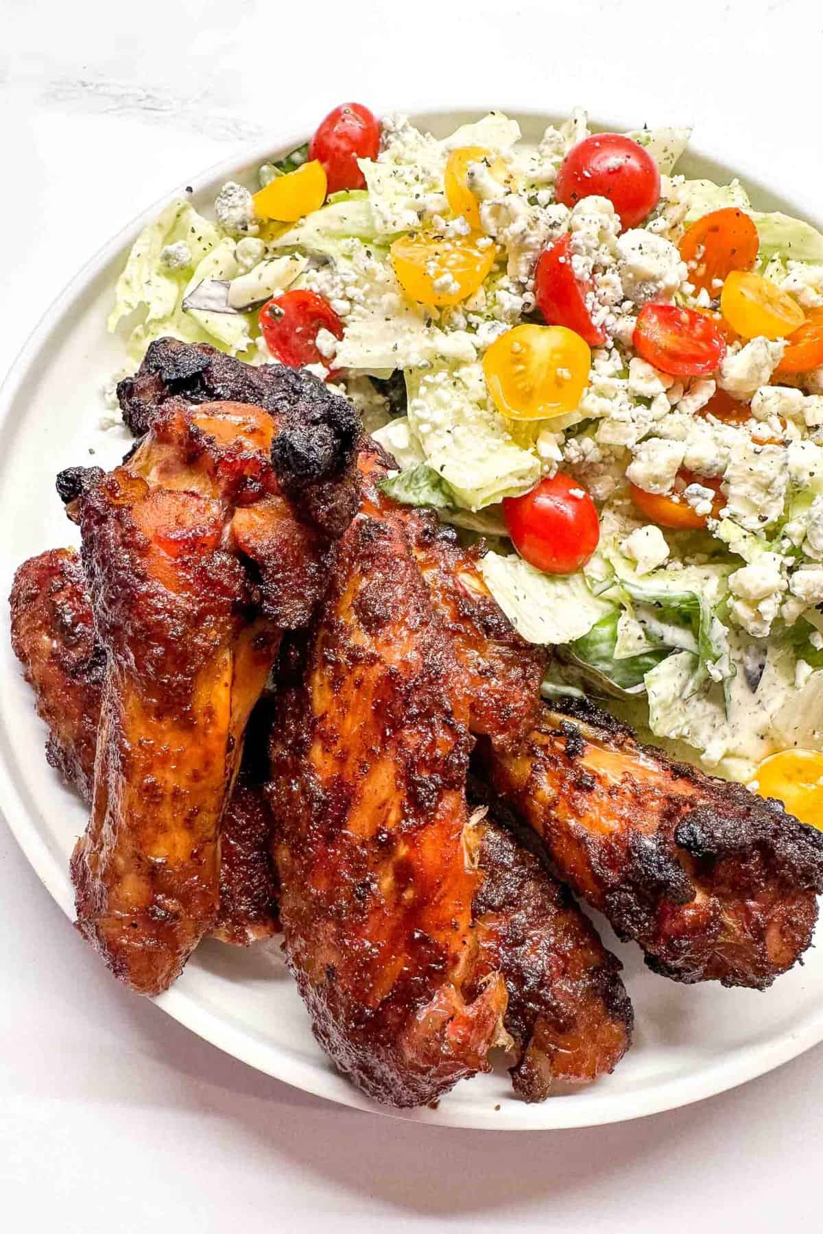 a plate with wings and salad