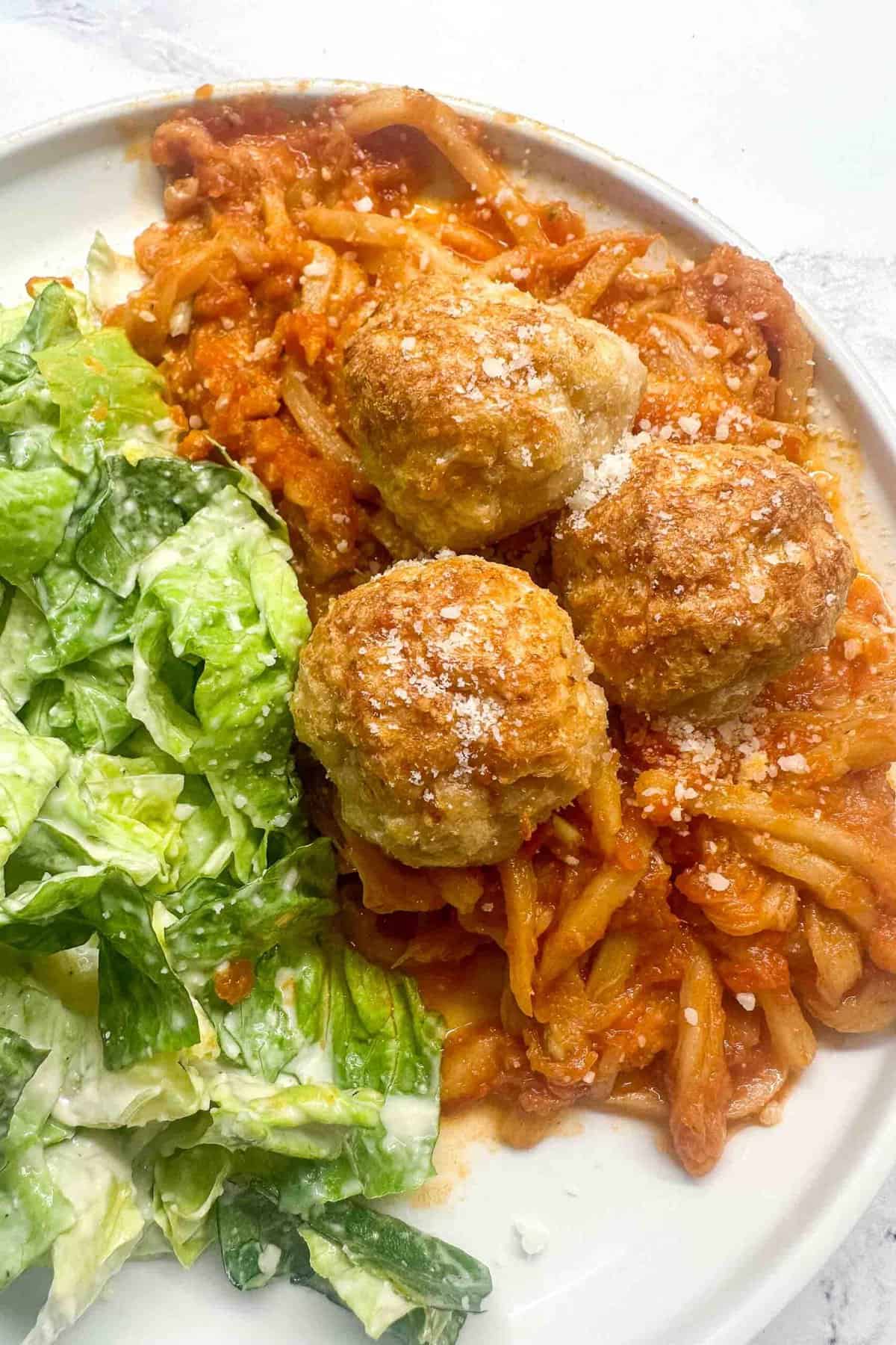 keto chicken meatballs ob a plate with side dishes.