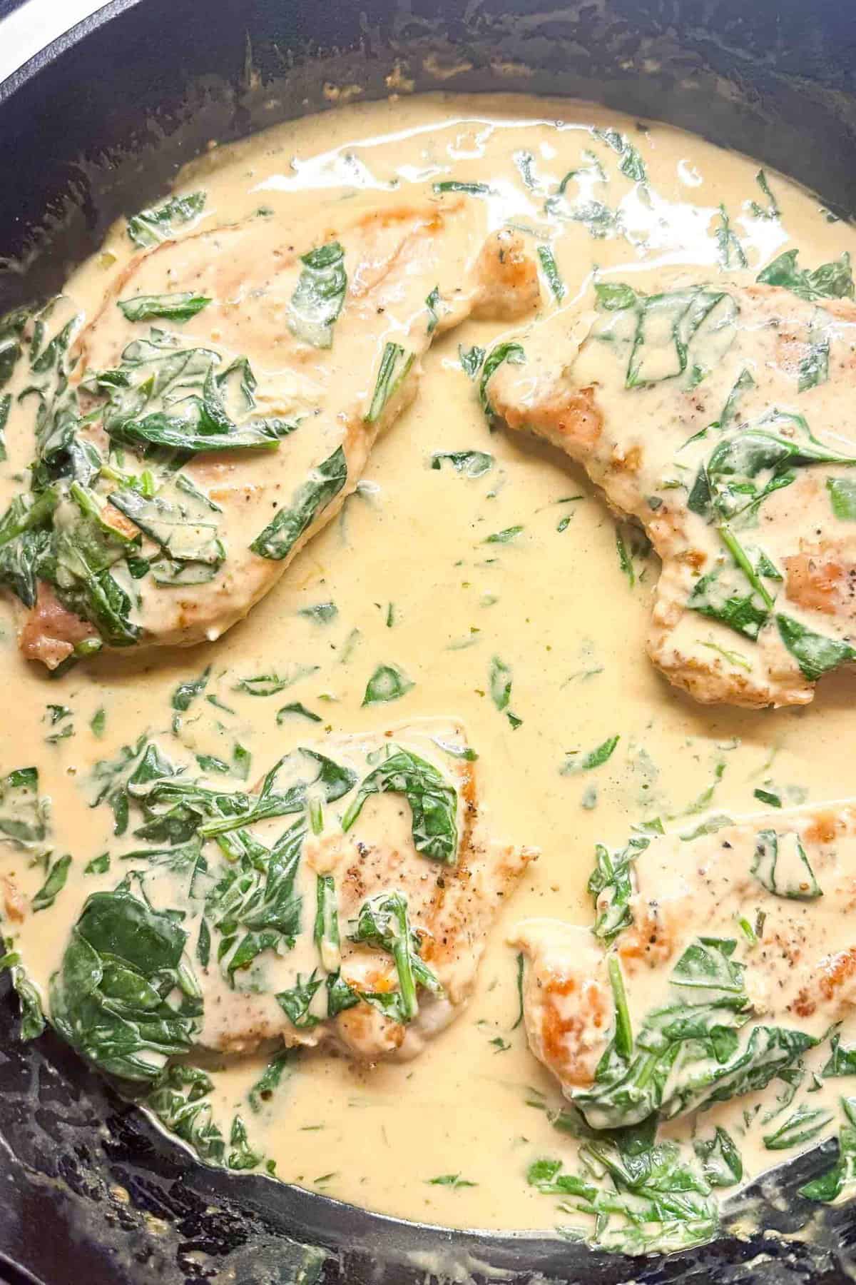 creamy boursin chicken cooking in a cast iron skillet