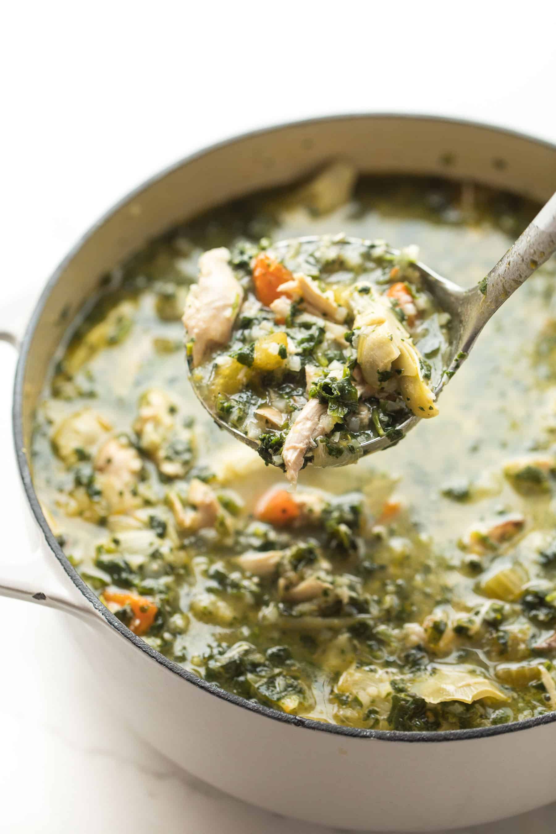 Lemon artichoke chicken soup in a dutch oven being ladled out