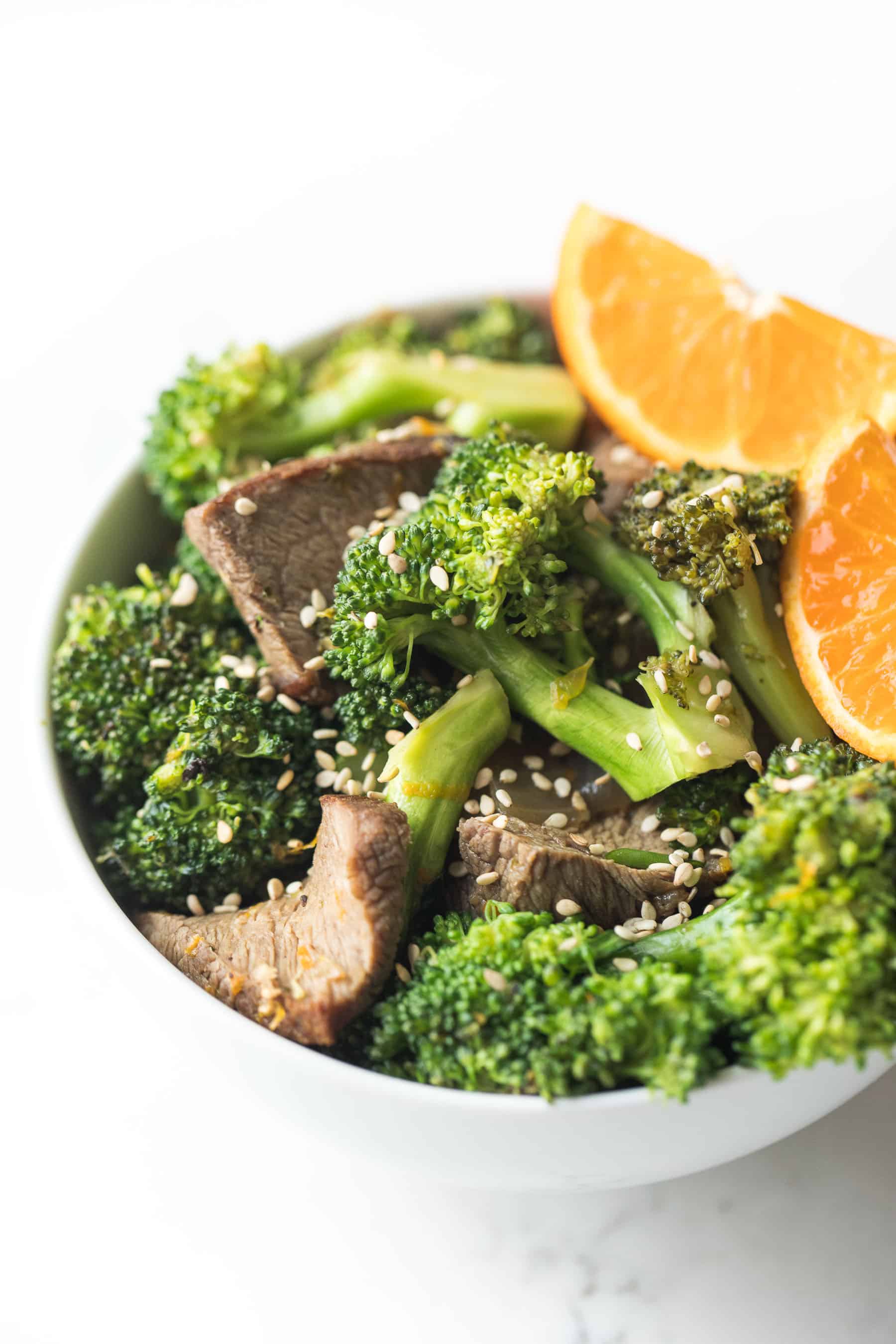 orange broccoli beef in a white bowl